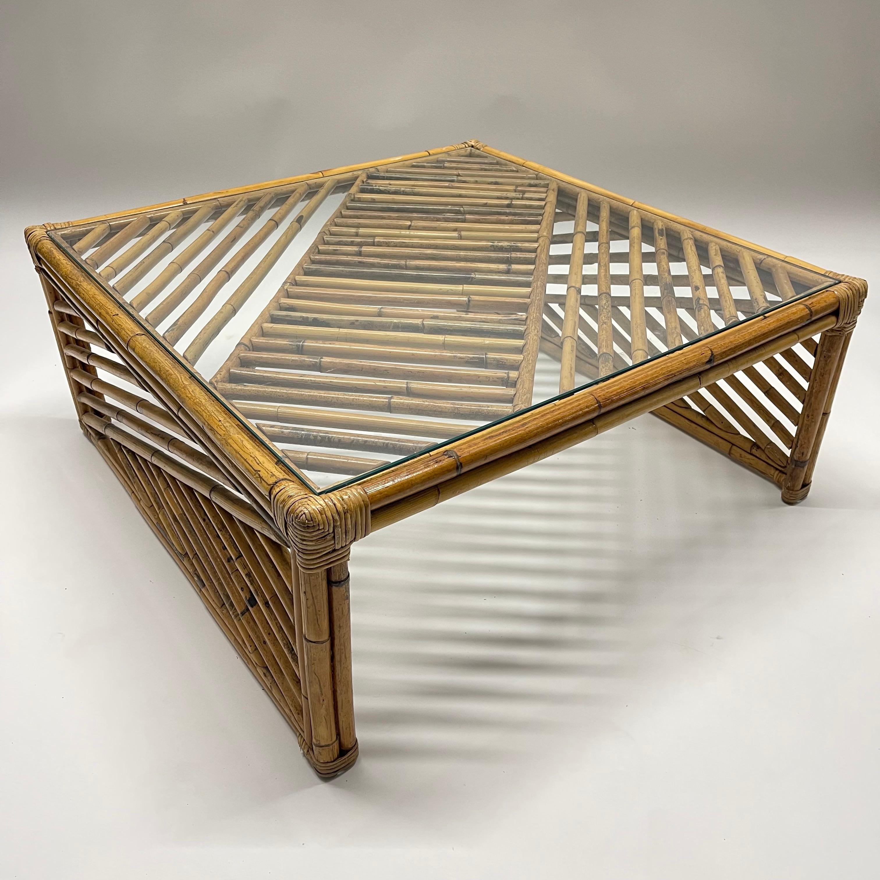 Post-Modern mid century geometric design coffee or cocktail table rendered in rattan bamboo with a glass top, 1970s.