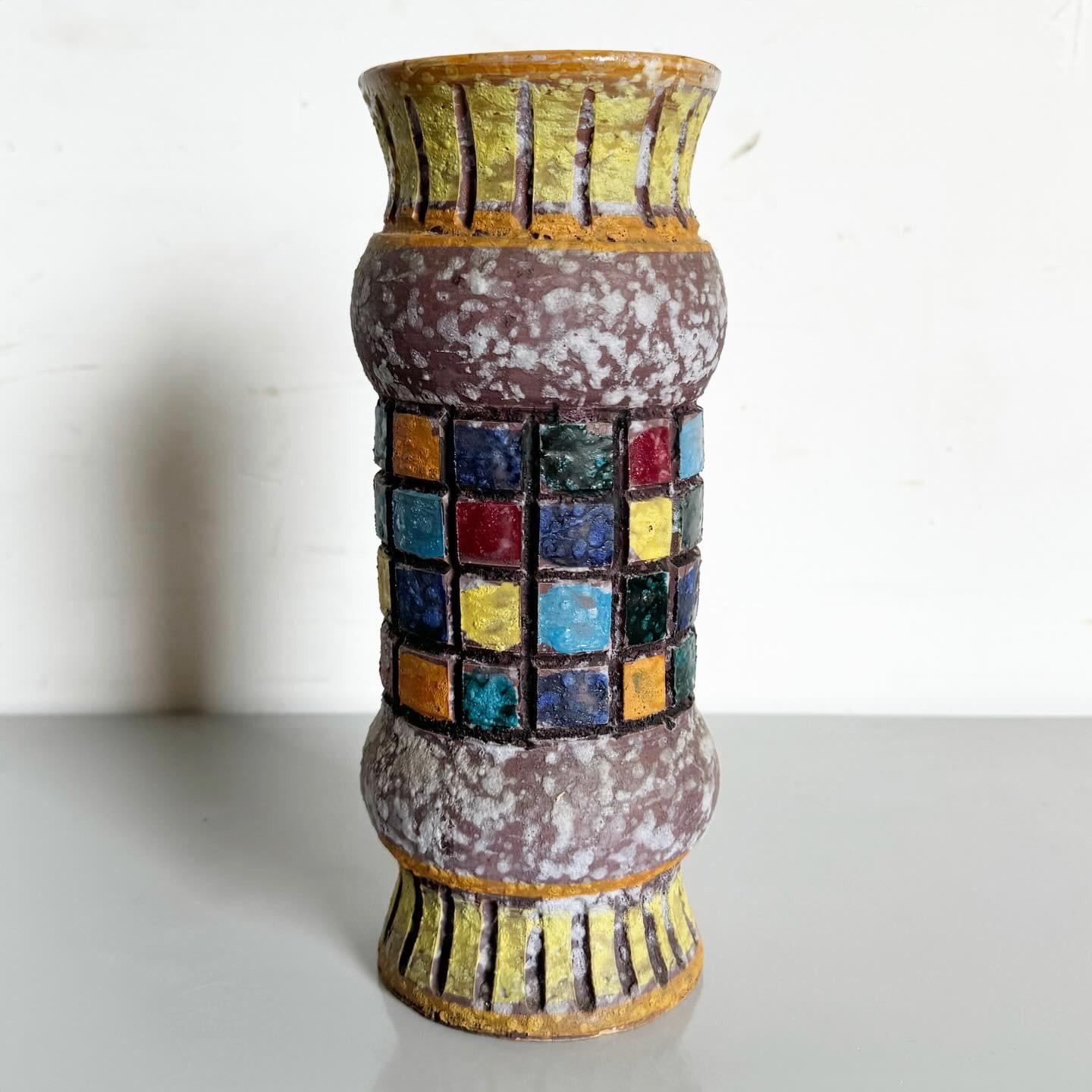 Add a splash of retro elegance to your decor with this Post-Modern Mid Century Table Vase. The vase showcases a sleek design adorned with multicolored square patterns, embodying mid-century Post-Modern aesthetics. Its vibrant motifs against a simple