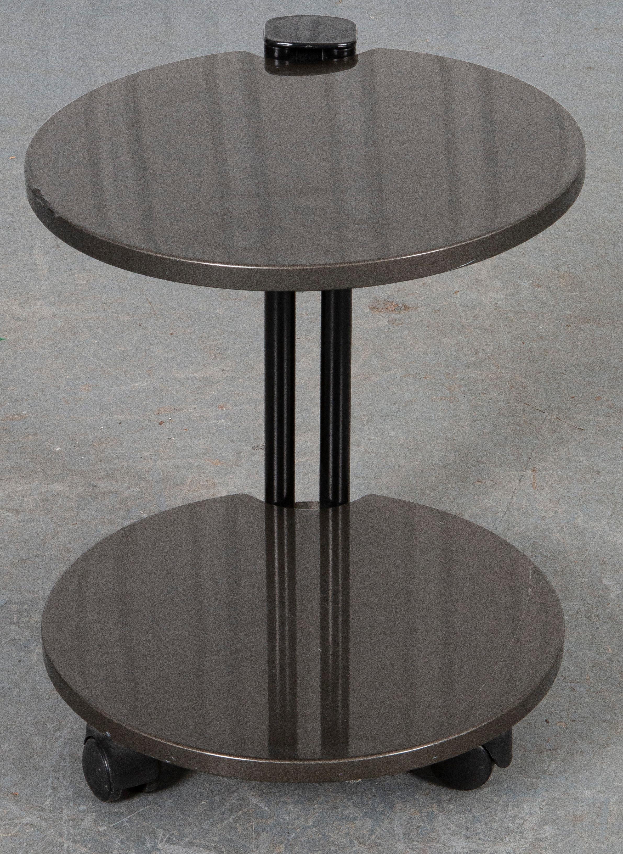 Table d'appoint post-moderne en matériaux mixtes à deux niveaux, le plateau rond et le niveau inférieur étant suspendus par un support en forme de colonne.