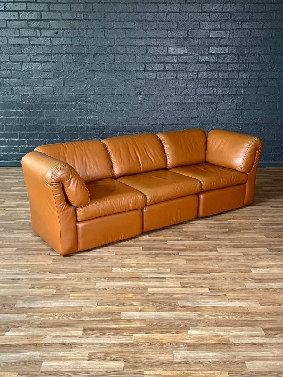 Condition: Original Vintage Condition
Materials: Original Carmel Leather

This plush Post Modern modular sofa, made in the U.S. during the 1980s, features three individual sections upholstered in buttery-soft original caramel leather. Its rounded