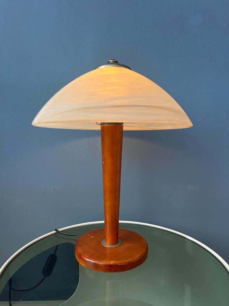 Post modern table lamp with big patterned glass shade and wooden base. The lamp requires one E27/26 lightbulb and currently has an EU-plug.
2x pieces available

Additional information:
Materials: Glass, wood
Period: 1970s
Dimensions: ø Shade: 31