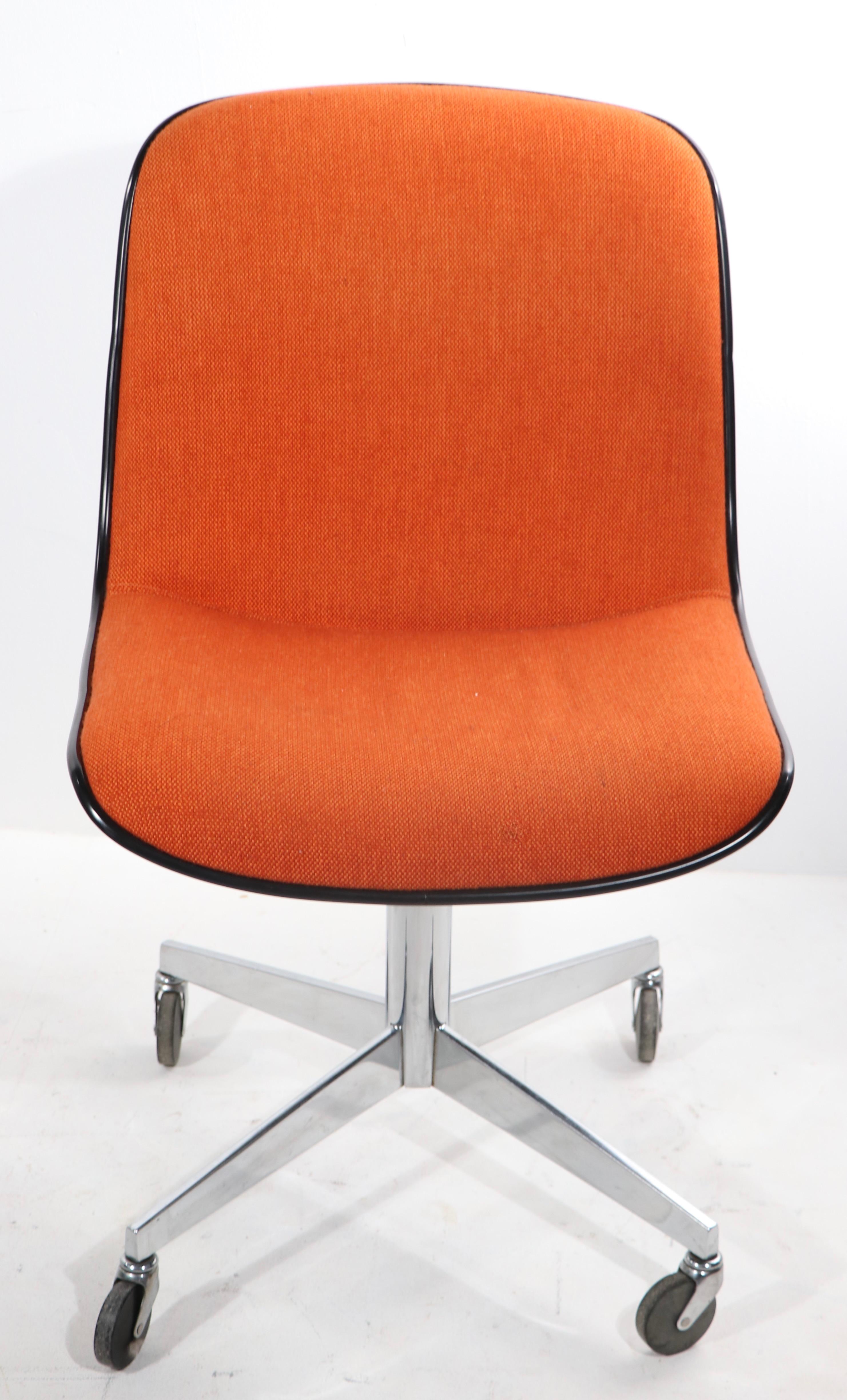 Chic architectural and ergonomic office, desk, side chair by Steelcase. This chair features a continuous seat and back in orange tweed fabric upholstery, dark grey plastic exterior shell, and chrome pedestal, four star base, mounted on wheel