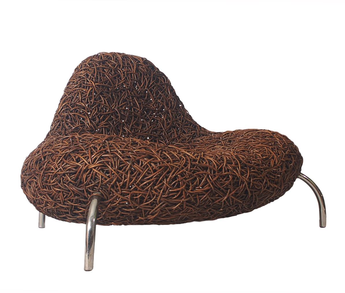 An incredibly unique design in organic rattan by Udom Udomsrianan and produced by Planet 2001. Consists of woven jungle vines with stainless steel legs. Out of production with limited number produced. Manufacture label.