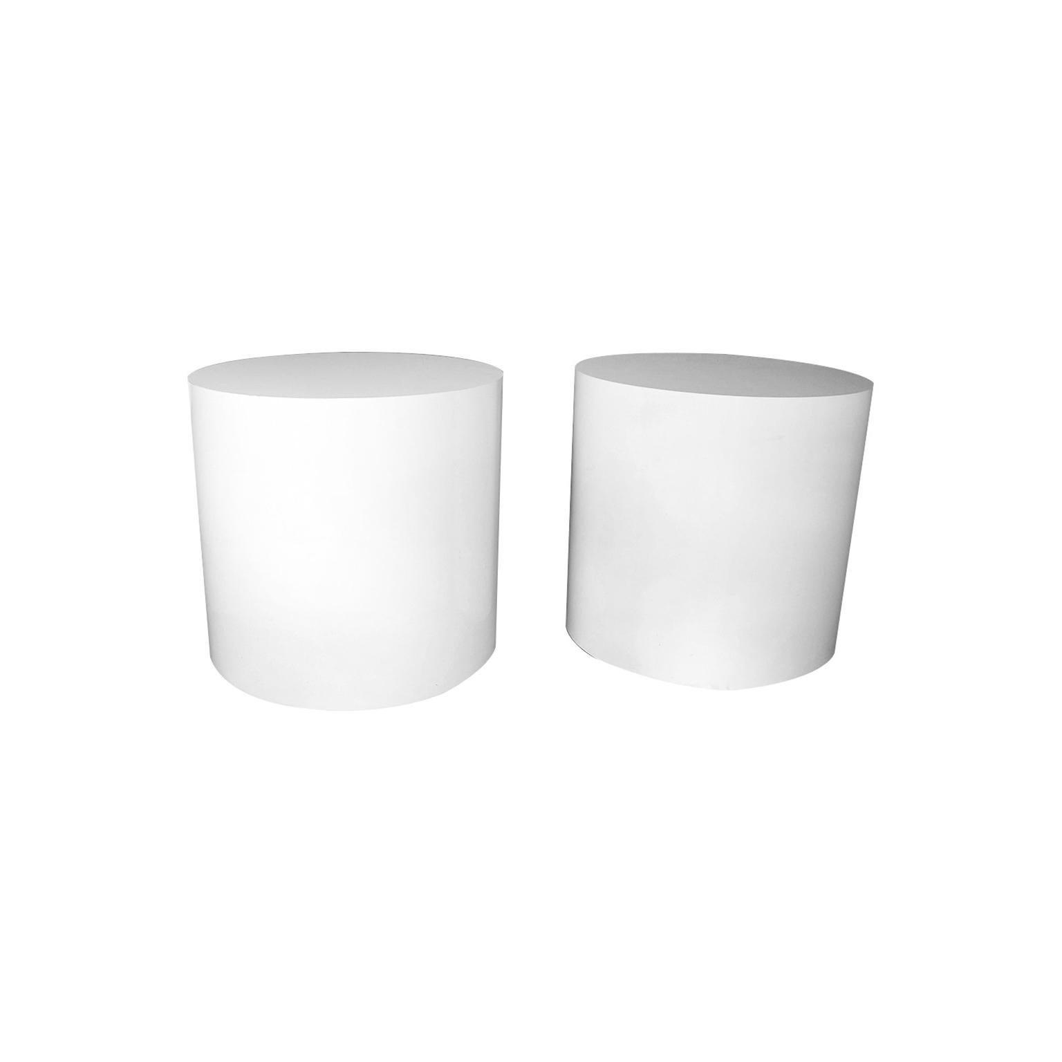 Striking pair of modernist white cylindrical drum end tables or display pedestals, circa 1980s. They feature durable water-resistant laminate veneers that are securely bonded to sturdy wood frames. Combining simple Minimalist elegance and bold