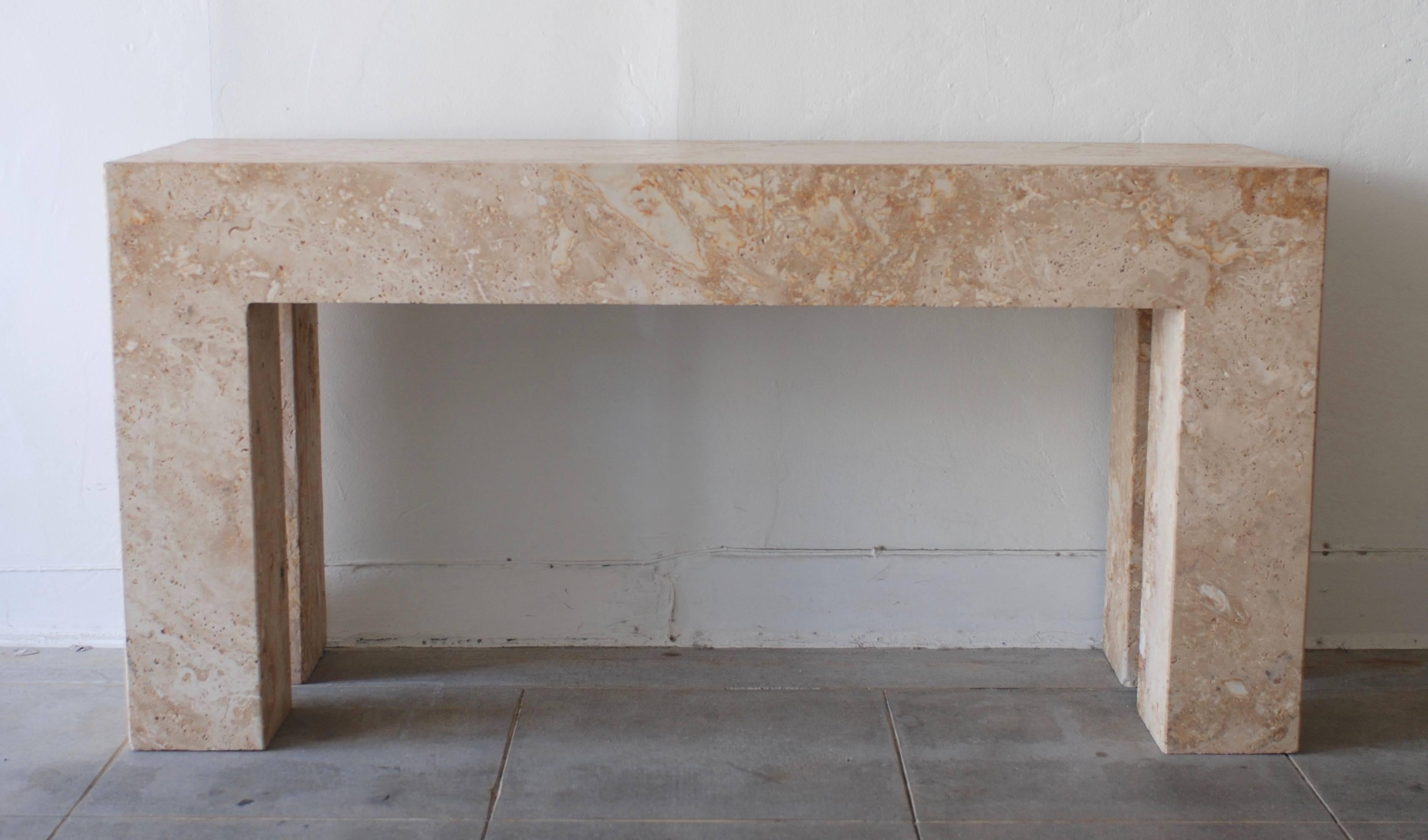In the style of Steve Chase this heavy travertine console table has great proportions. The travertine has a pale warm almost golden color.