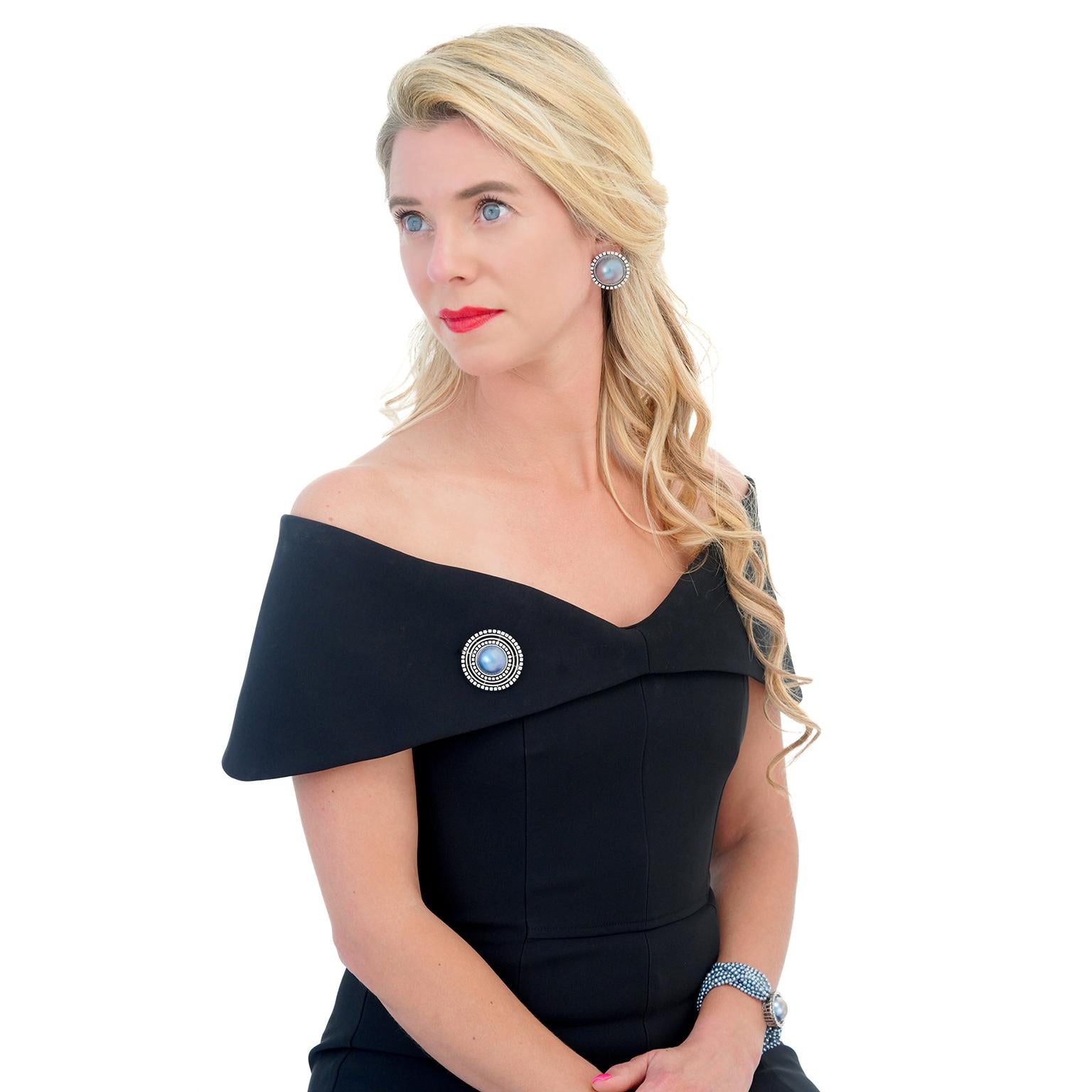 Circa 18k, c1990s Switzerland.  This striking Swiss Modern brooch features a 20.0-millimeter delicately iridescent Tahitian pearl and 3.0 carats of brilliant white diamonds (H color, SI1 clarity). Exceptionally contemporary, it is perfect for the