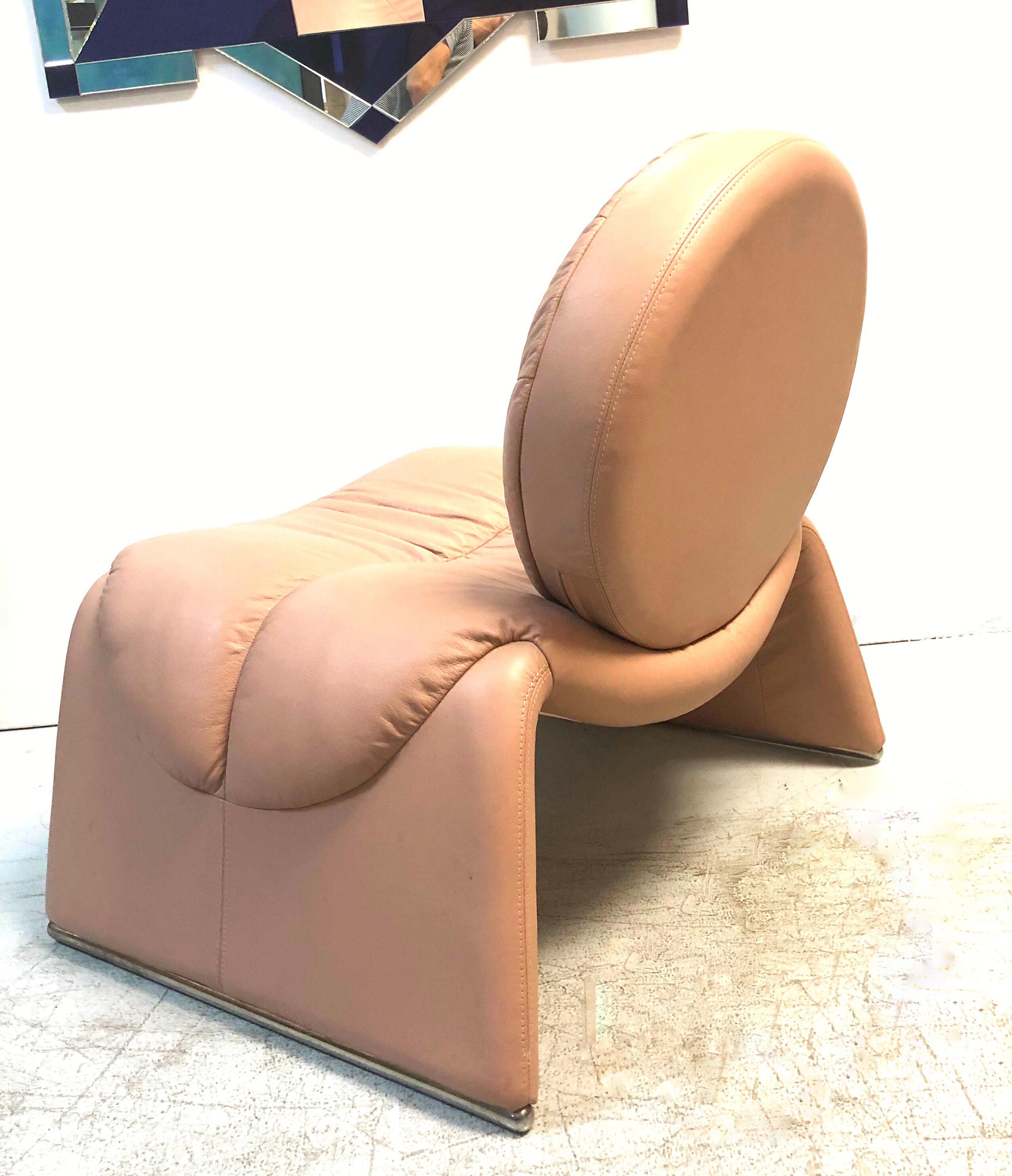 A pink leather postmodern lounge chair. Round back on a simple waterfall seat with chrome feet. Very plush.