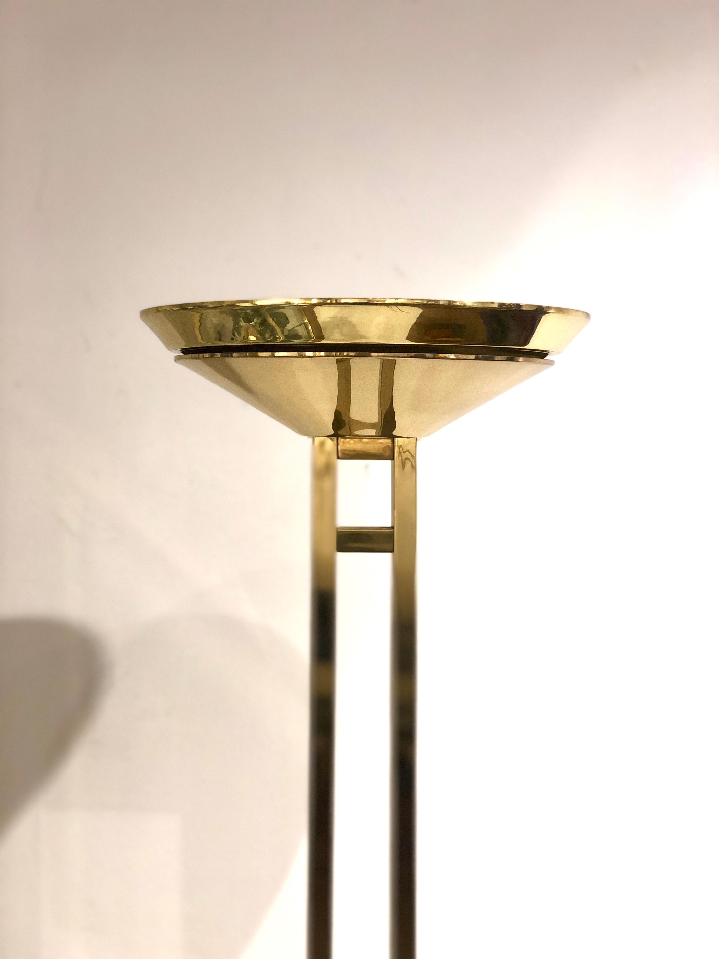 Postmodern polished brass torchiere floor lamp by Forecast Lighting of California circa 1980s nice and heavy the base shows natural patina due to age. Its in perfect condition takes a 250 watt halogen bulb the top of the lamp has a protective