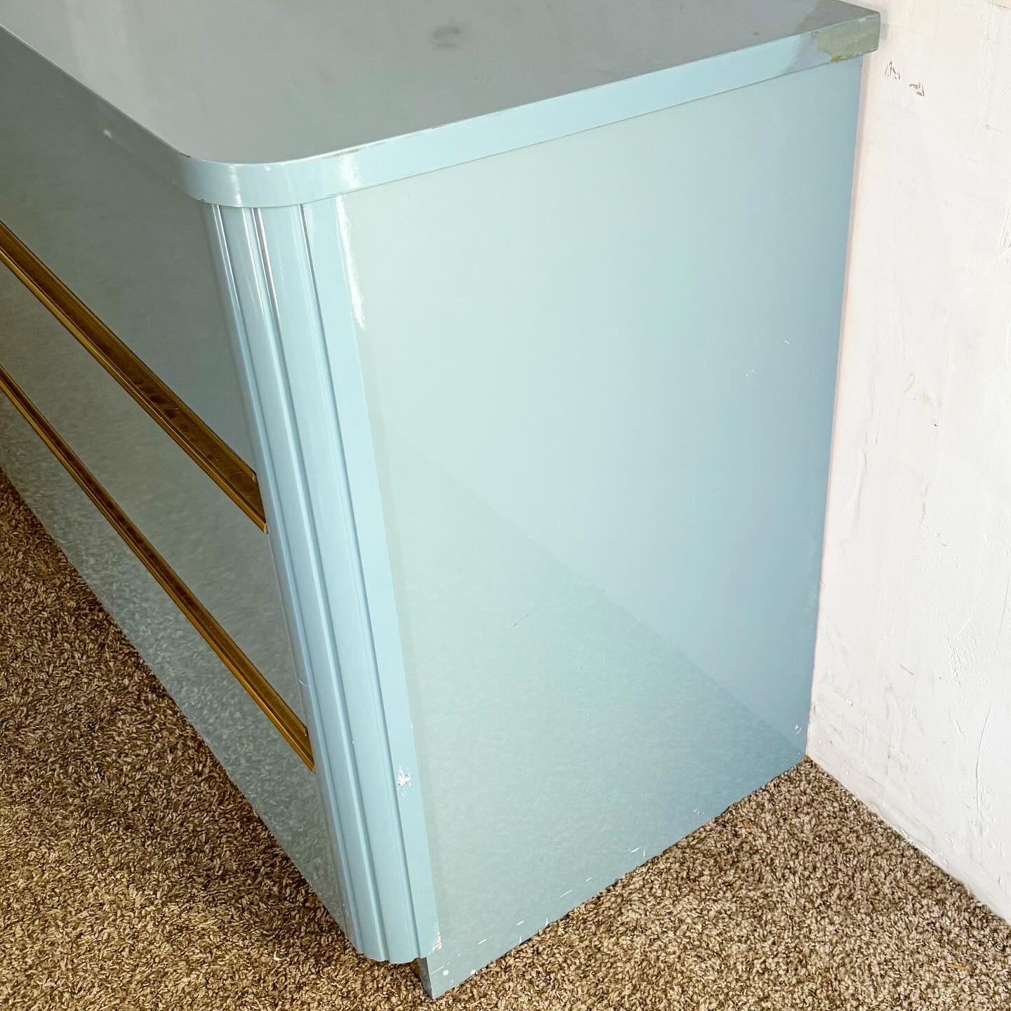 Experience modern elegance with the Post-Modern Postmodern Baby Blue Lacquered Dresser with Gold Accents. This dresser showcases a vibrant baby blue lacquered finish, enhanced by luxurious gold accents. Its sleek lines and minimalist form reflect