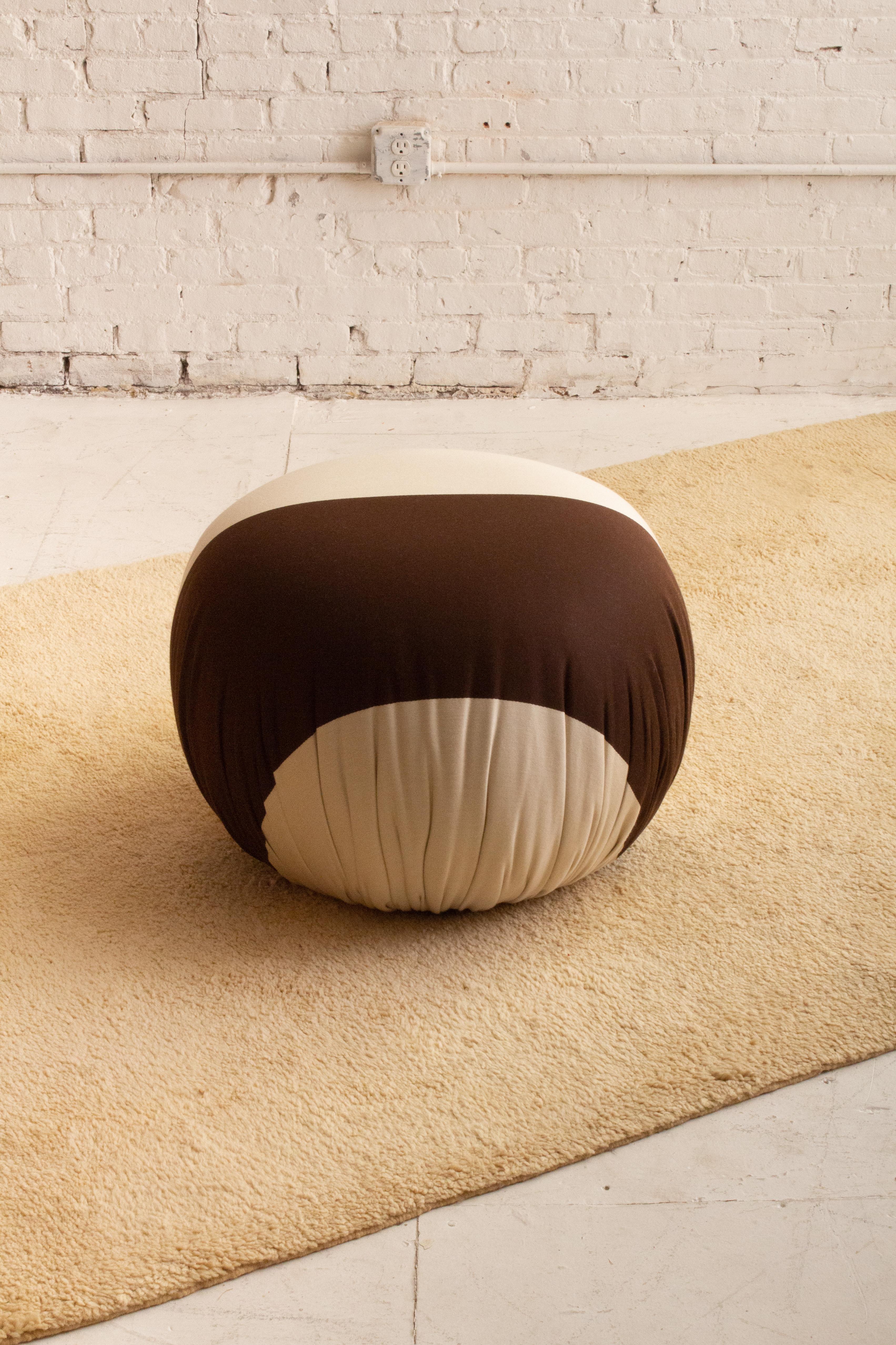 A post modern pouf ottoman by Weiman. Newly reupholstered in a cream and brown striped jacquard. Two available, sold separately.