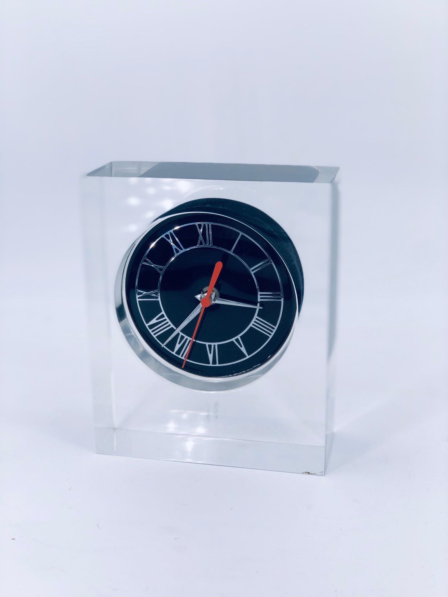 A beautiful solid Lucite table clock designed by Junghams circa 1970s, battery operated and working condition keep good time. Roman numbers in silver and black Lucite face, German movement.