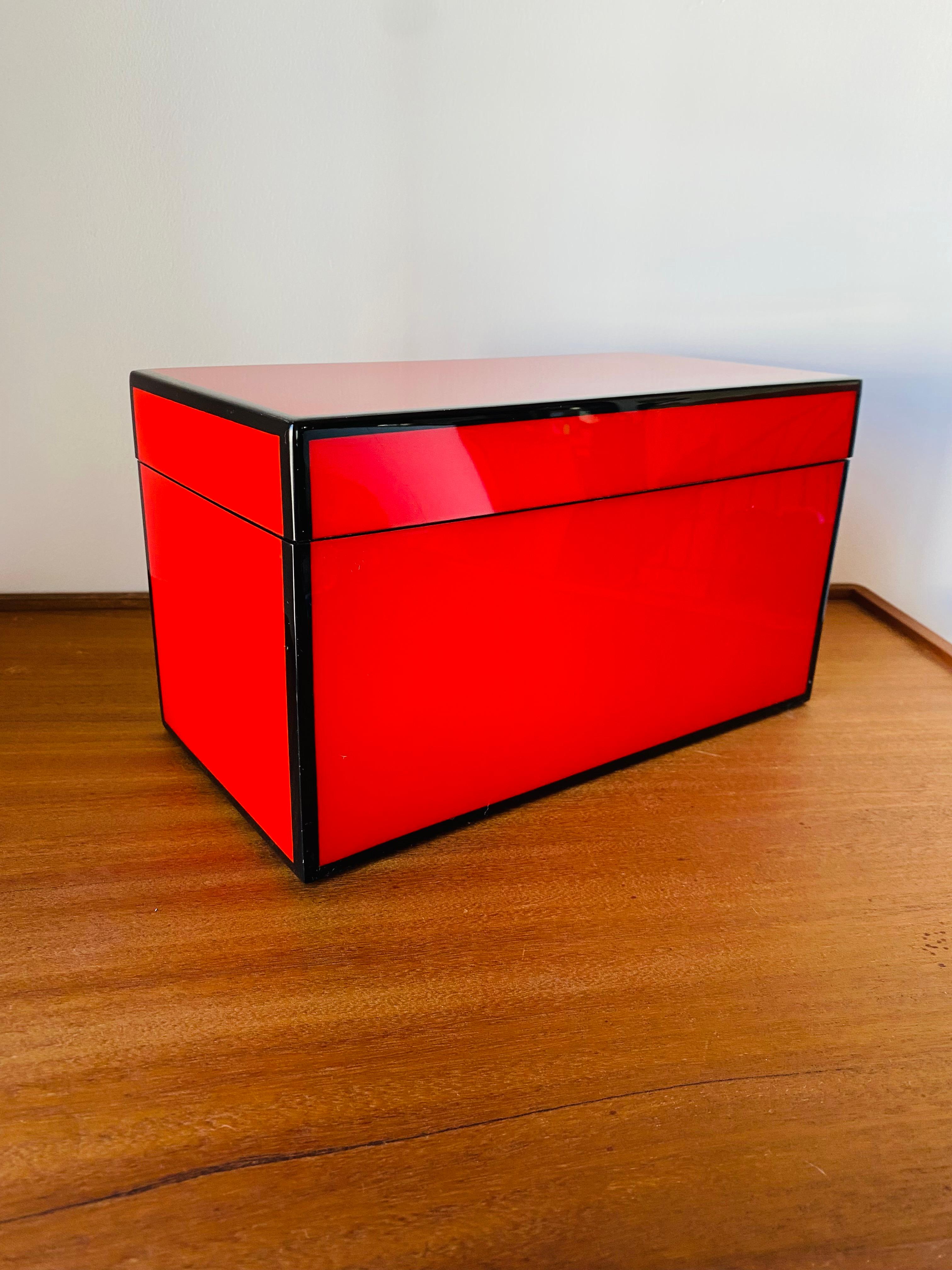 Incredibly sleek multi-use decorative jewerly box by Gump's San Francisco.  This beautiful  box is divided in 3 compartments and lined with black velvet.  High sheen, electric red lacquer delineated in edges in black.  Unique, high impact piece that