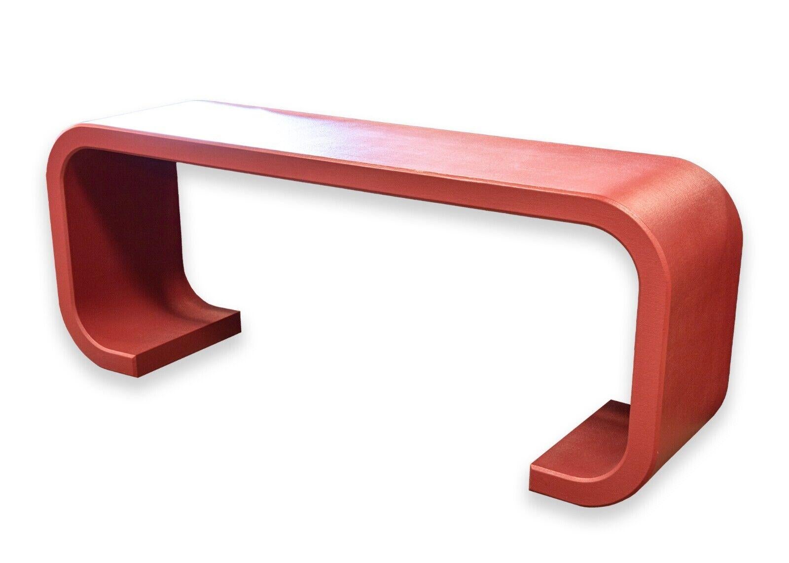 A post modern red waterfall console table. A lovely console table with a classic post modern design. This piece features a rich, deep red color finish and a waterfall design. This piece is in very good condition. It measures 27.75 in tall, 72 in