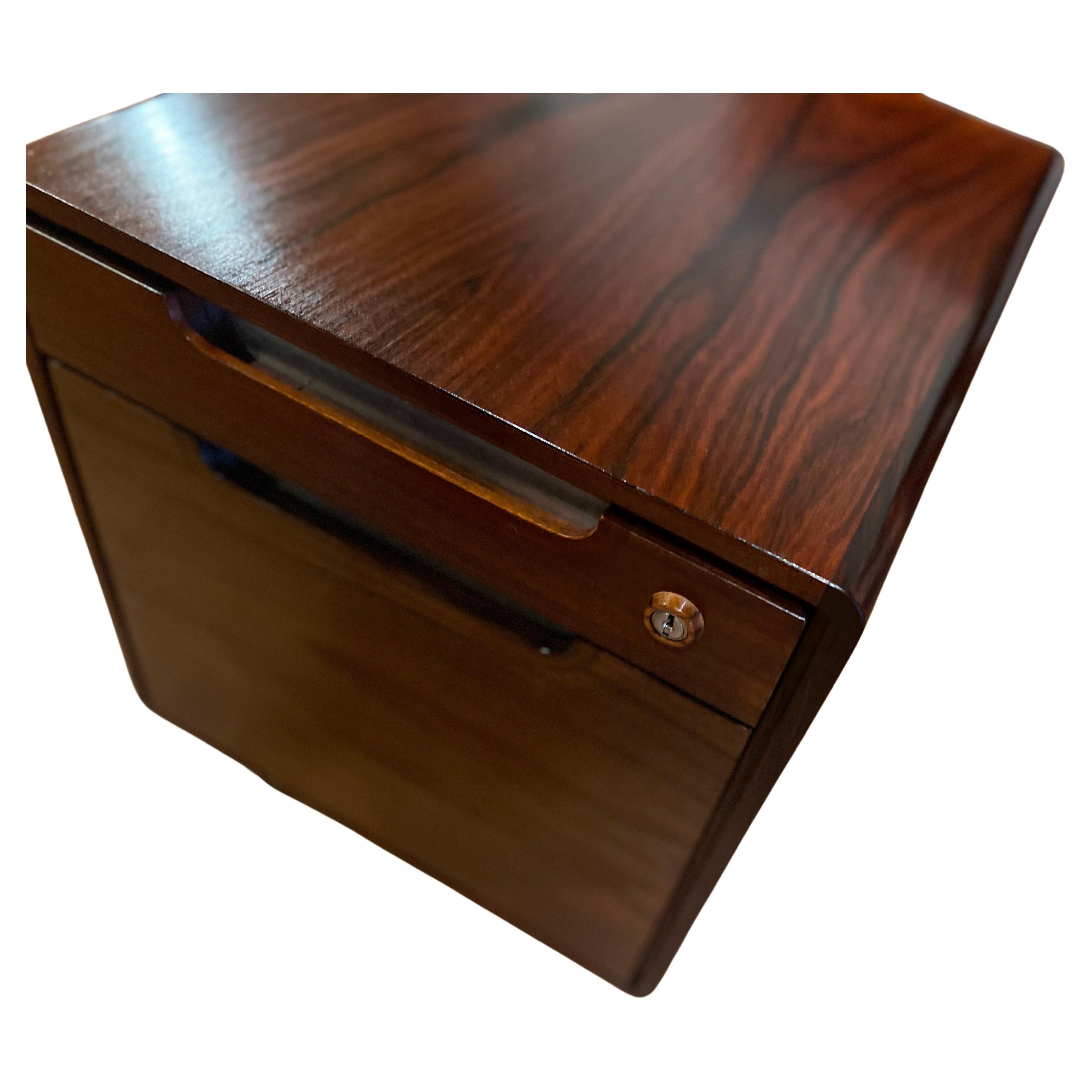 Gorgeous piece with incredible quality and craftsmanship circa 1980's rosewood case on casters, rolls beautifully the drawers slide like butter, and has a solid wood removable tray wrapped in leather, the key is missing, very heavy piece made in