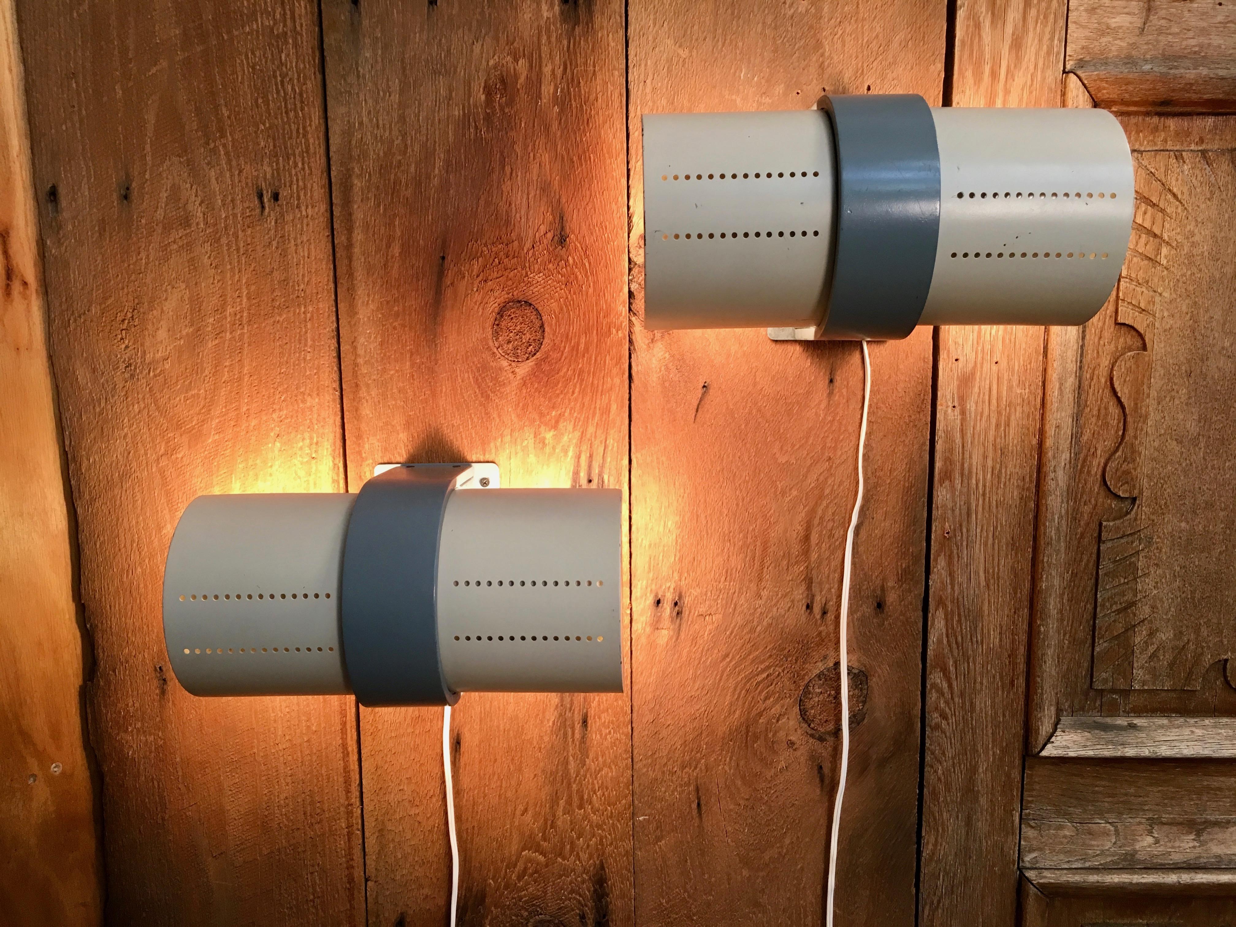 A pair of modernist two-tone painted metal wall lights. The shades are adjustable to direct the light up or down or on a slant.