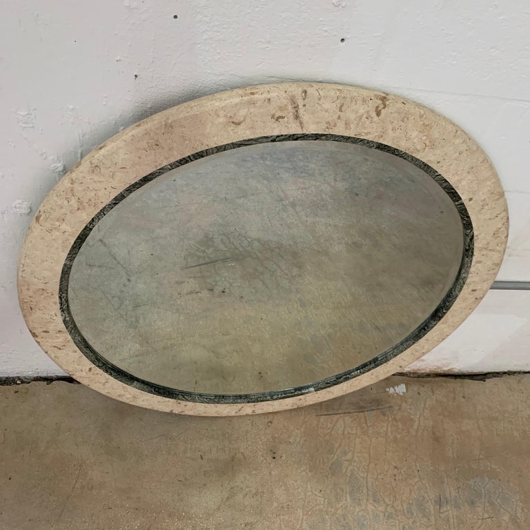 Round stone frame mirror rendered in two tones of travertine and marble with a beveled inset mirror, by Maitland Smith, 1980s.