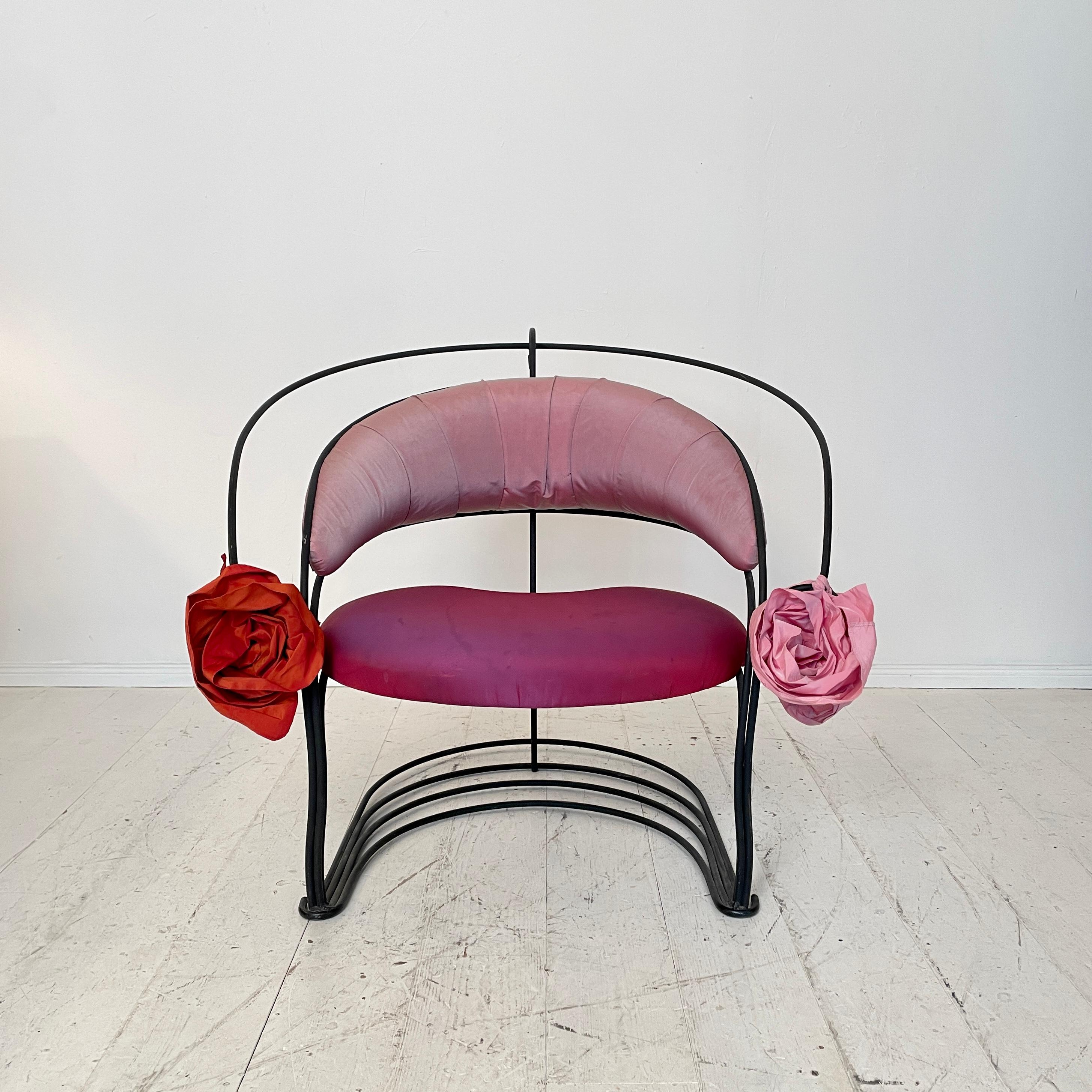 This fantastic Italian Post-Modern sculptural Armchair was made in the 1980s.
It is made out of black lacquered metal and has got a pink and red Silk Upholstery.
At the End of the Armrest is has got big flowers made out of Silk.
A very rare and