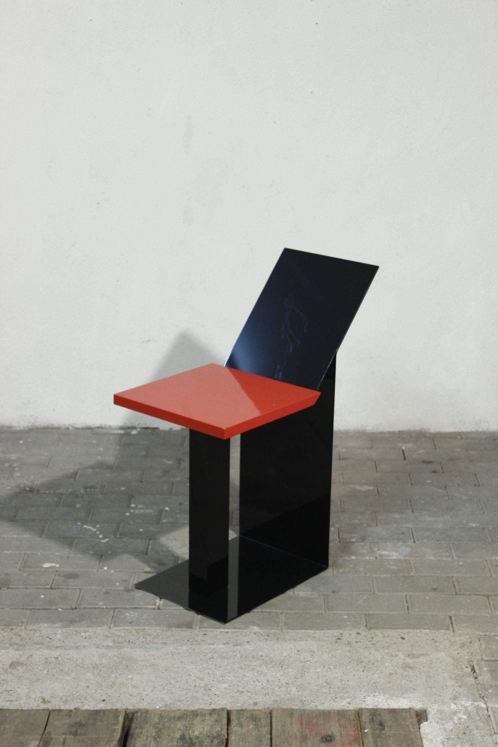 Original side table or pedestal in a radical postmodernist design, composed of black-painted folded sheet metal and red-lacquered particleboard.

Its dimensions make it ideal as a sofa end or pedestal table, although its design is reminiscent of a