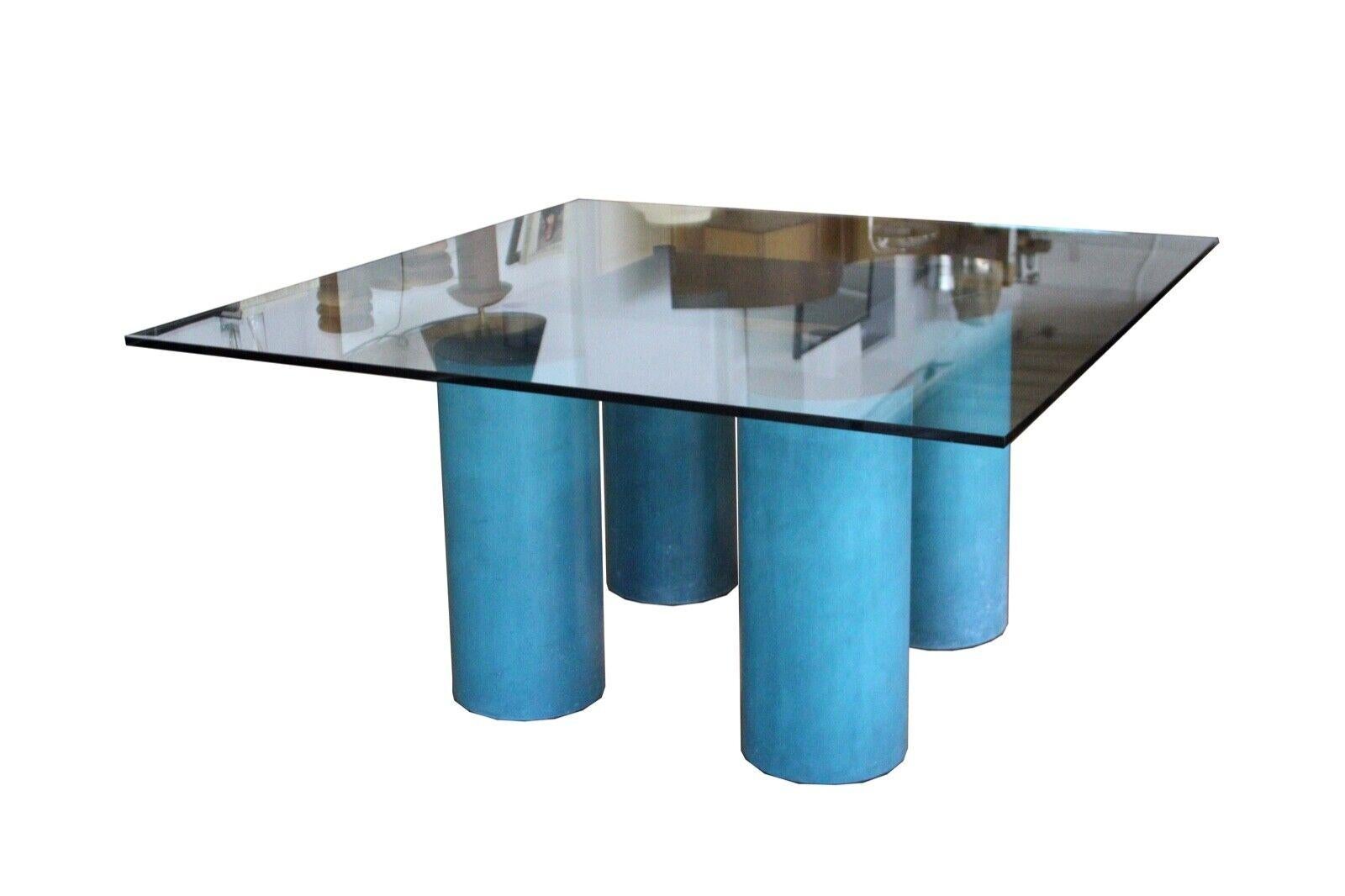 Le Shoppe Too presents this magnificent Post Modern designed table or desk by Leila and Massimo Vignelli. 4 turquise painted metal columns support the gloating glass top. In great condition. Dimensions: 57