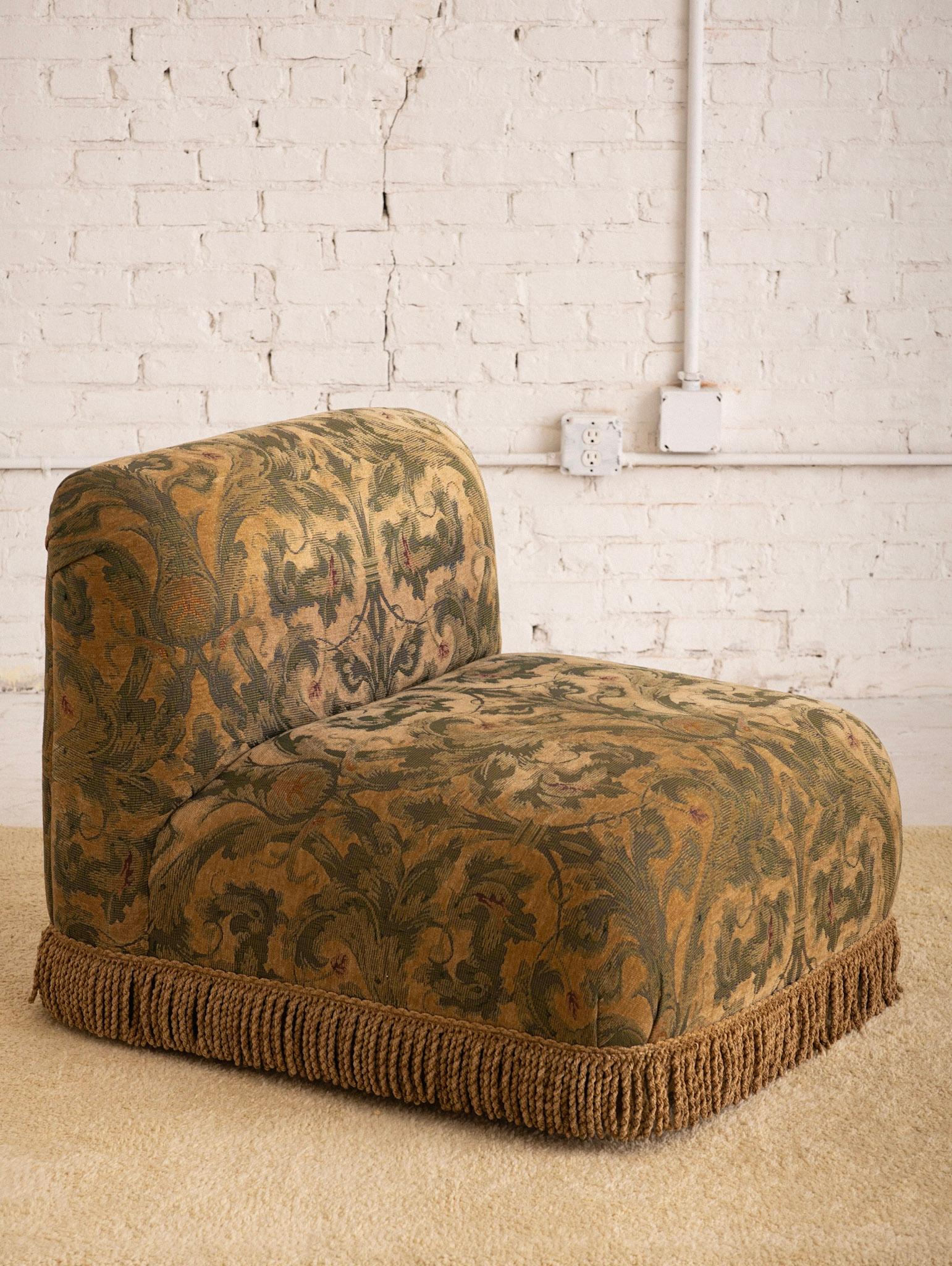 Post Modern slipper chair in a tapestry print fabric with fringe trim. Simple low profile silhouette. Can be reupholstered at your discretion. 2 available.