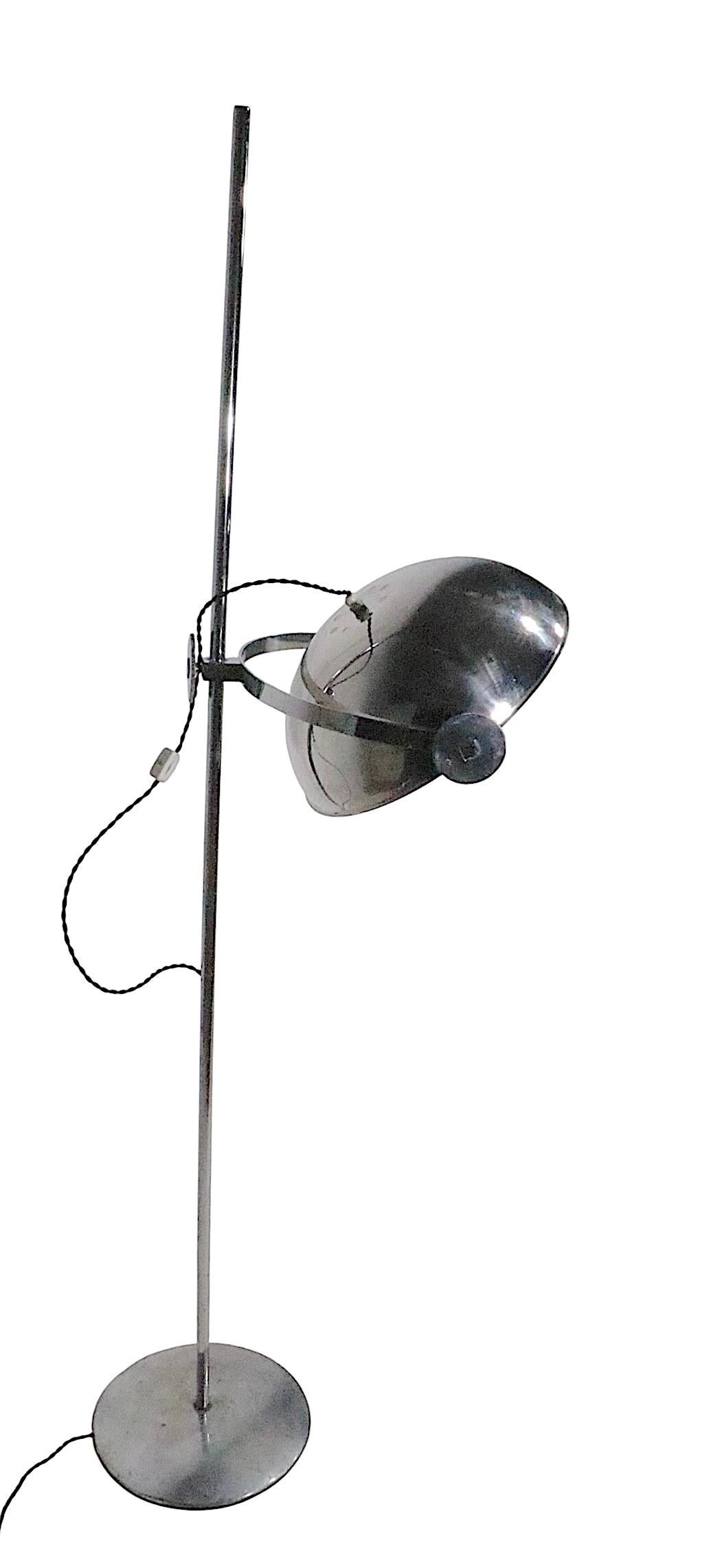 Cool adjustable chrome floor, or reading lamp, having a large bowl form shade which tilts within the U shaped holder, which in turn can be raised and lowered on the vertical  center post . We believe this lamp was produced in Italy circa 1960/70's,