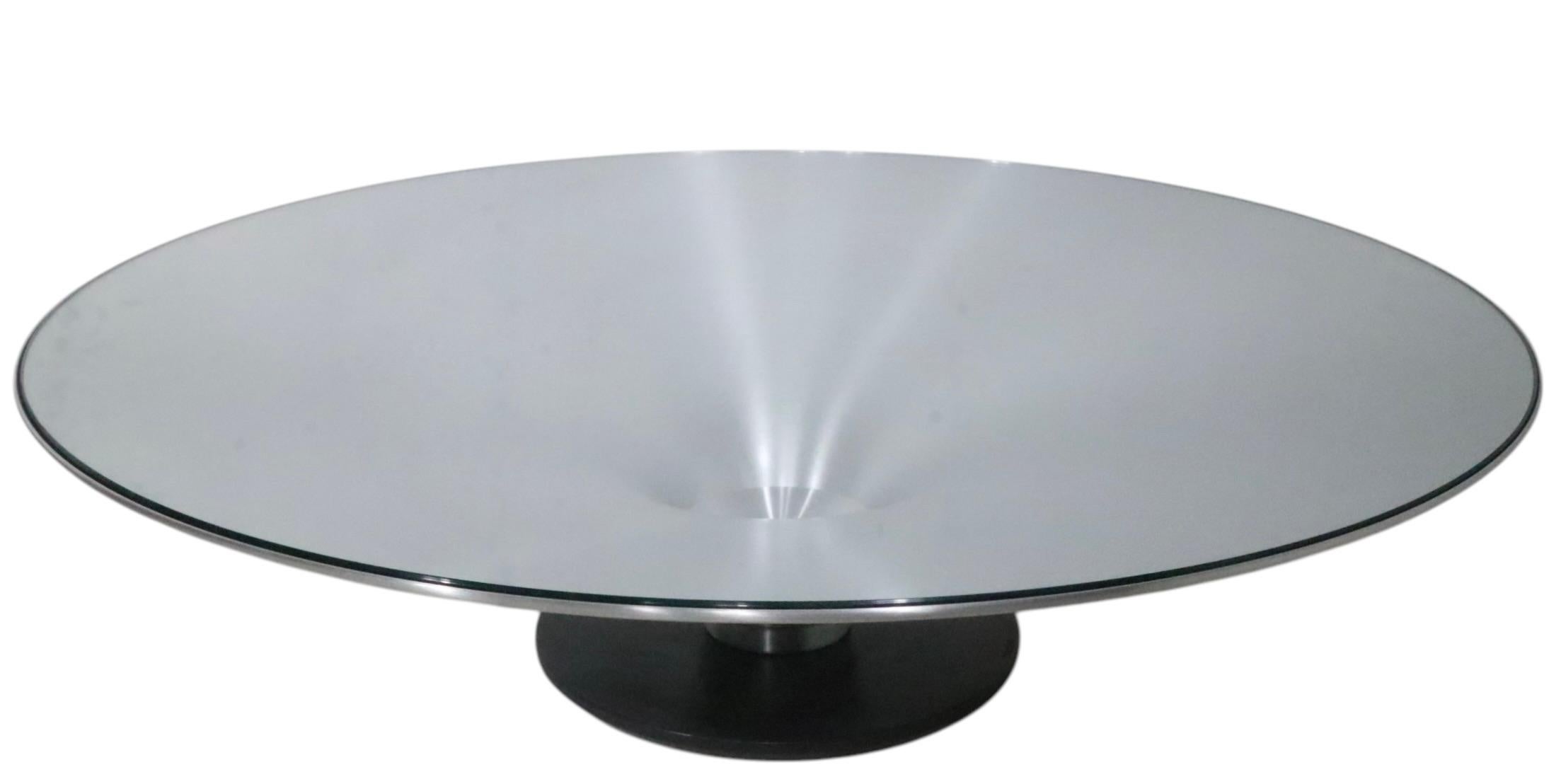 Voguish, chic, architectural  Ovni Up coffee, cocktail table designed by Vincenzo Maiolino for Roche Bobois, circa 2000/2020. The table features a trumpet form base of spun aluminum, mounted on a cast metal base, with a tempered glass insert top.