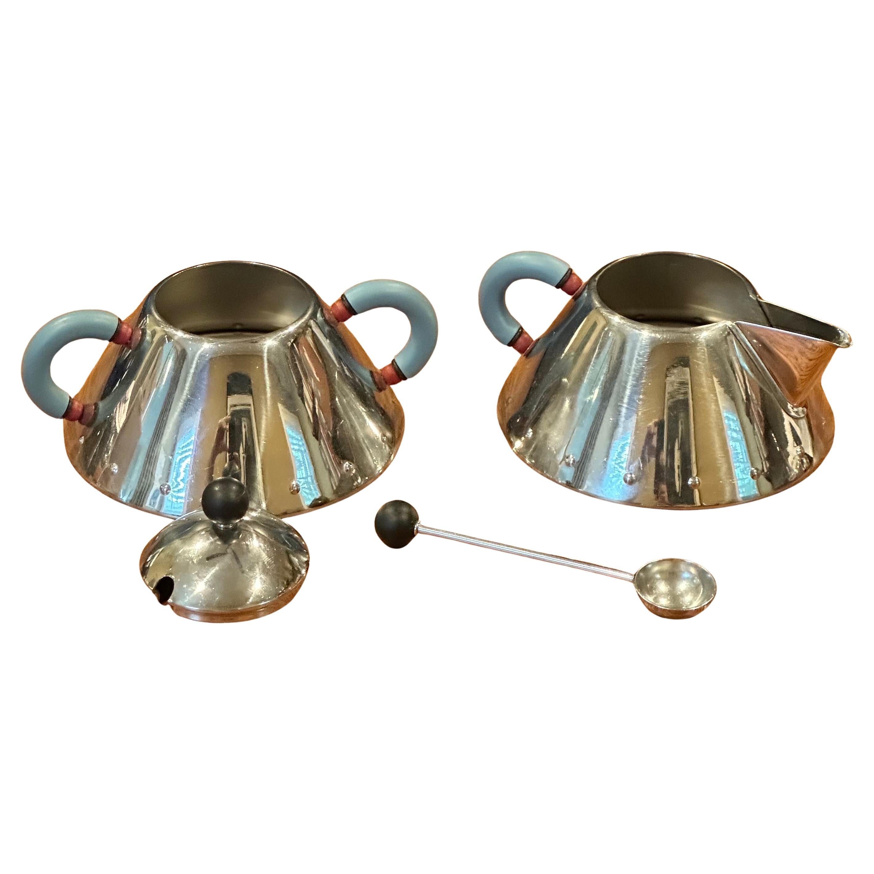 Clásico juego posmoderno de crema y azúcar de acero inoxidable diseñado por Michael Graves para Alessi, hacia la década de 1980. El conjunto está en buen estado vintage y mide  5