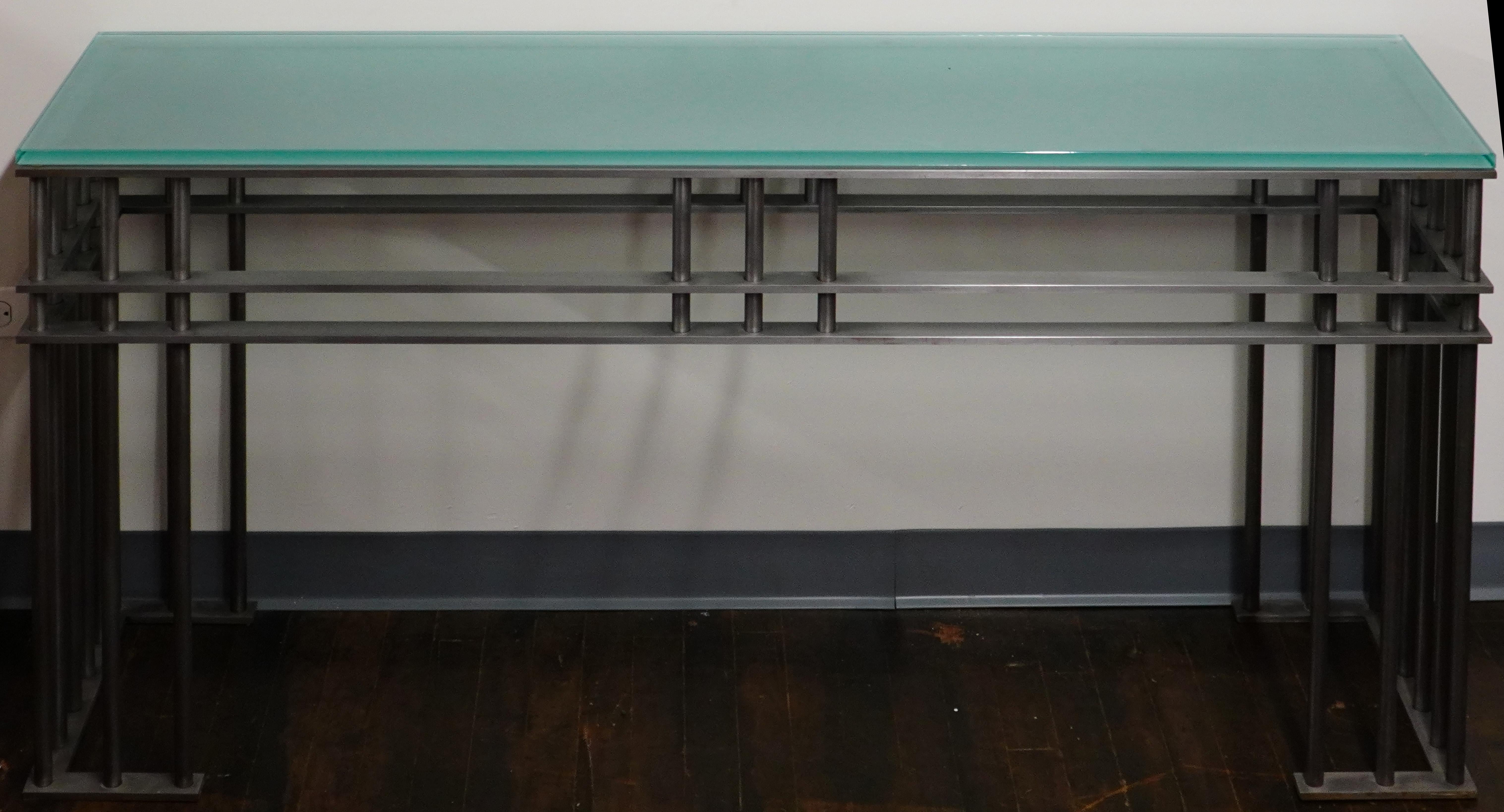 A wonderful post-modern console table that has a somewhat industrial looking steel base and a frosted glass top.  

Circa 1980, this piece resembles a design by the French artist, Jean-Michel Wilmotte, but is unsigned and cannot be authenticated. 