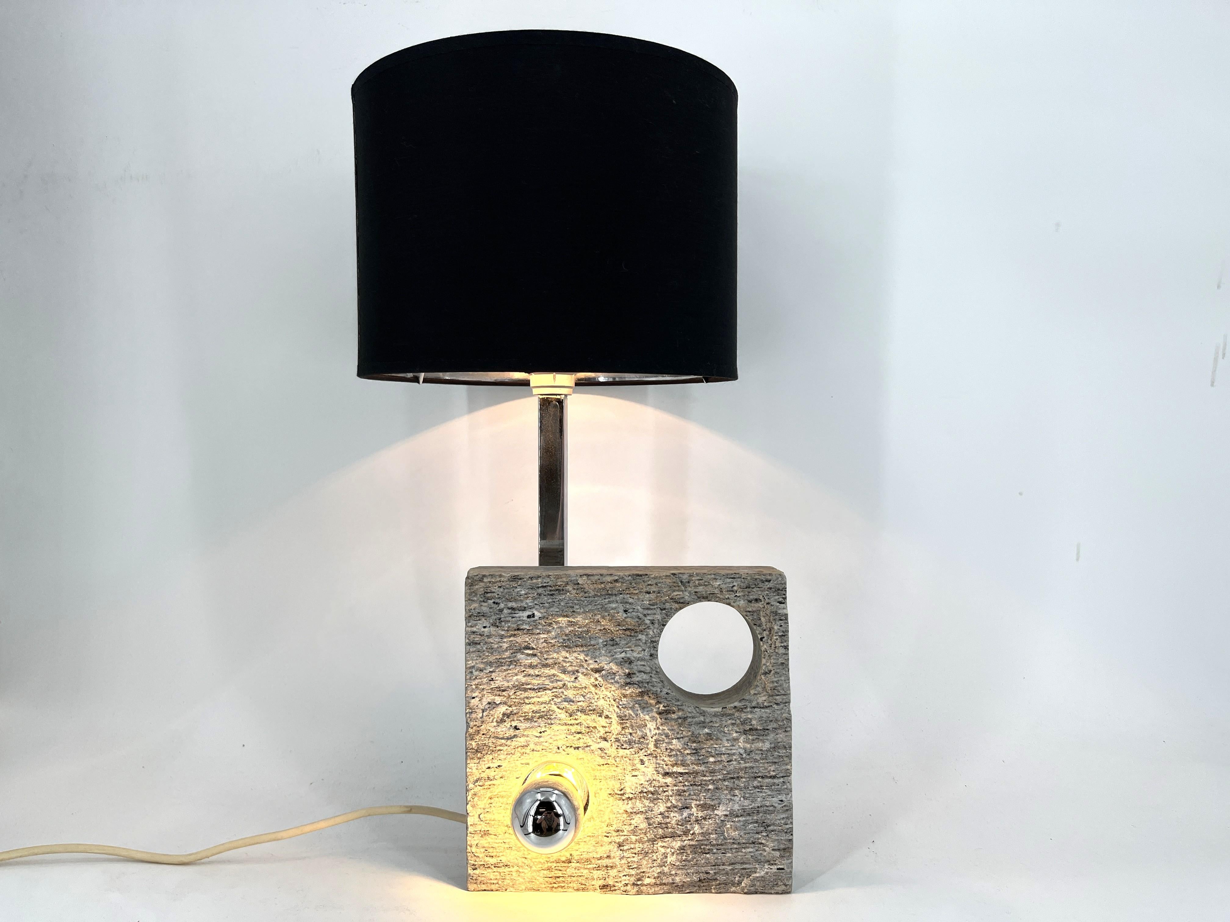Lampe de table au design post-moderne fabriquée à partir d'un morceau de granit, avec une ampoule intégrée, une tige en métal chromé et un abat-jour noir et argenté.

Belle pièce de design d'un artiste/designer inconnu.

Acquis en Italie vers la fin