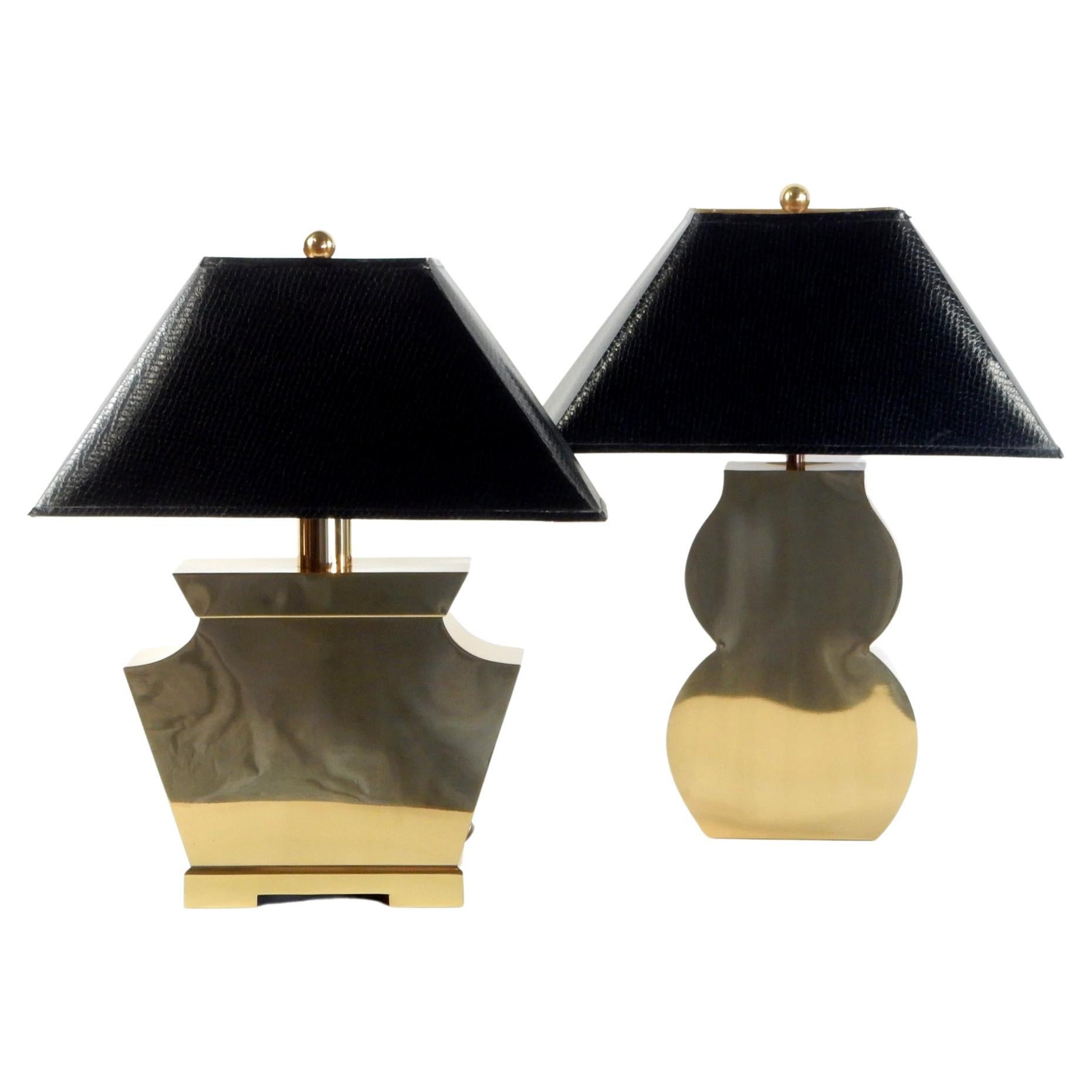 Post-Modern streamline table lamps constructed of polished brass. 
Original faux reptile skin covered shades with golden lining.
Different shapes that go well together. These are amazing lit reflecting
light and close objects.
Manufactured by