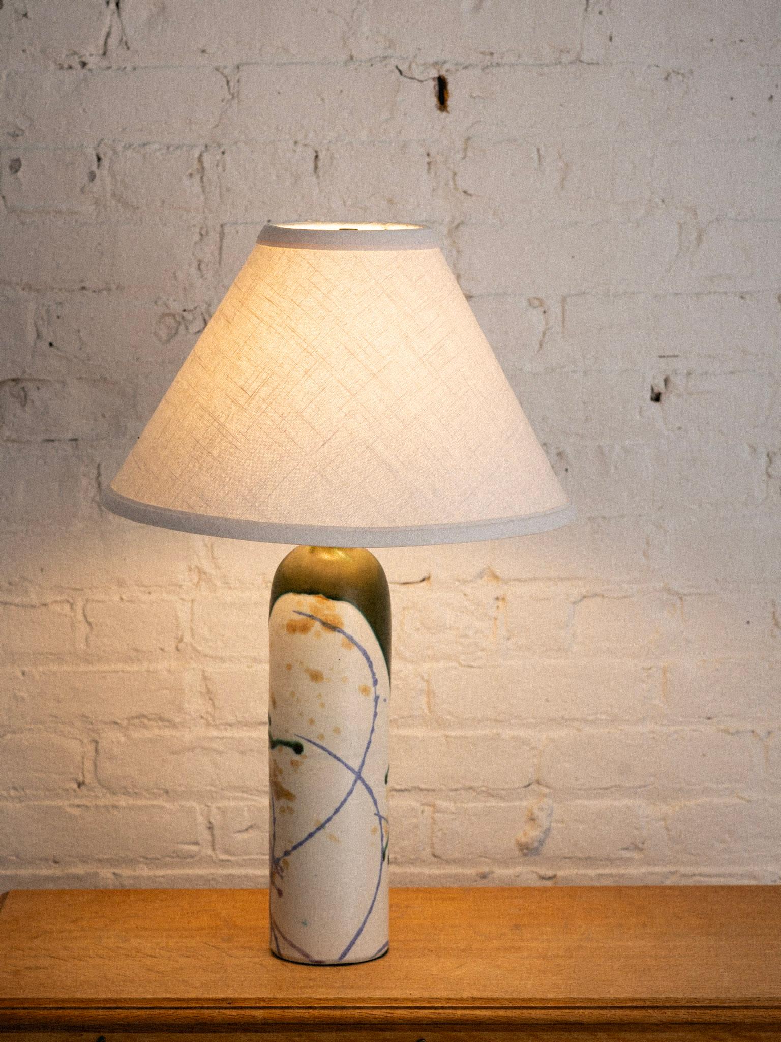 A post modern studio made ceramic lamp. Pillar shape silhouette with abstract splatter glaze. Two available with notable variations to glaze and size. One lamp base measures 16” and the other base 17.” Sold separately. Lamp shades not included.