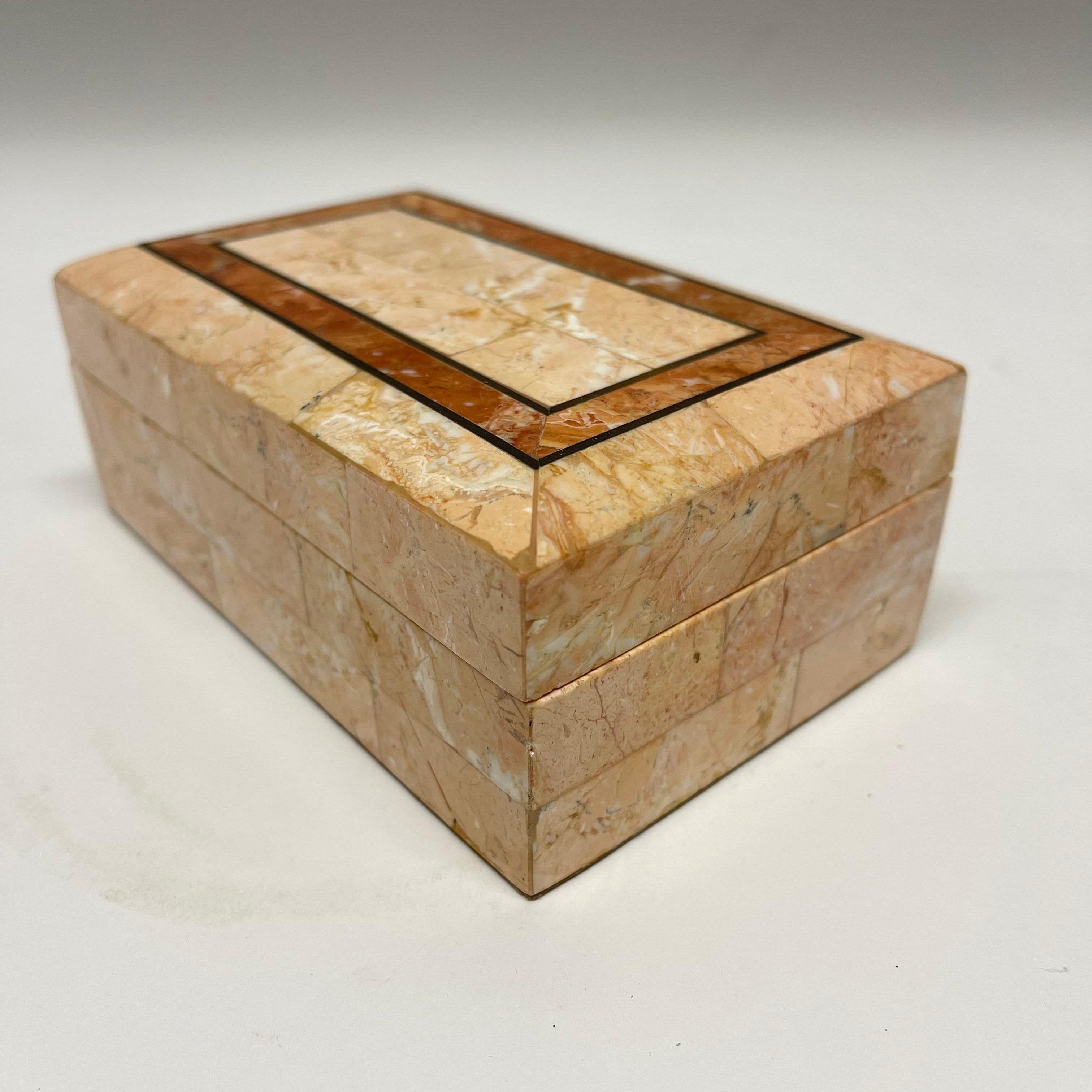 Post Modern tobacco or snuff box rendered in tessellated pink marble and rosso travertino, red travertine with brass inlay, brown velvet and wood interior by Maitland Smith.

Matching egg shaped pillar candle stick available item reference number