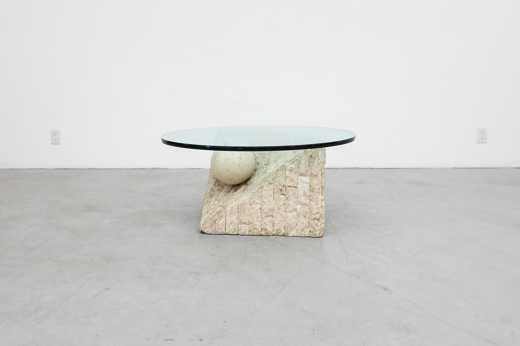 1995 Post-Modern coffee table with round glass (not original to table) and tessellated Mactan stone triangle base with suspended pearl design. The original design had a triangle glass top.  The Mactan fossil stone used here is quarried exclusively