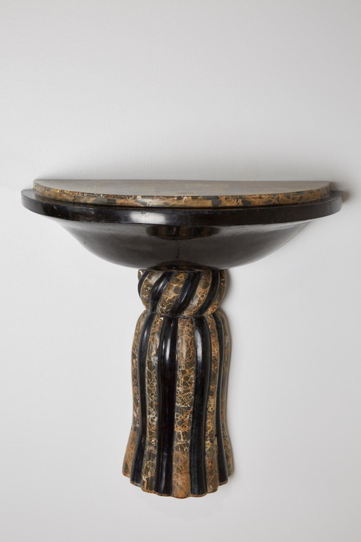 Wall-mounted shelf or wall bracket executed in black and snakeskin stone with decorative trompe l'oeil tassel detailing.

All furnishings are made from 100% natural Fossil Stone or Seashell inlay, carefully hand cut and crafted piece-by-piece and