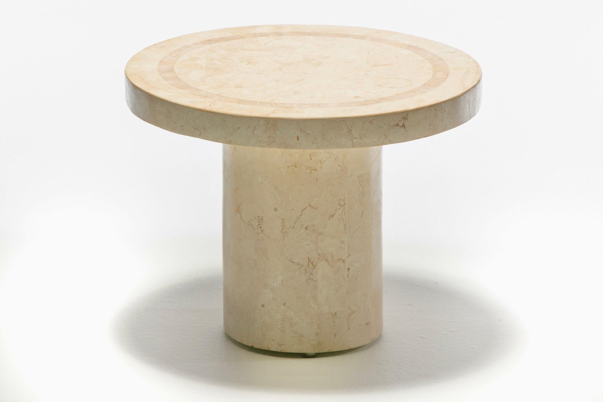 Tessellated travertine Post Modern table with rich grain and contrasting table top border detail. The vibe is clean and modern. Multi-tonal shades of ivory and cream travertine. Strong and sturdy central cylindrical base. Maintenance free travertine