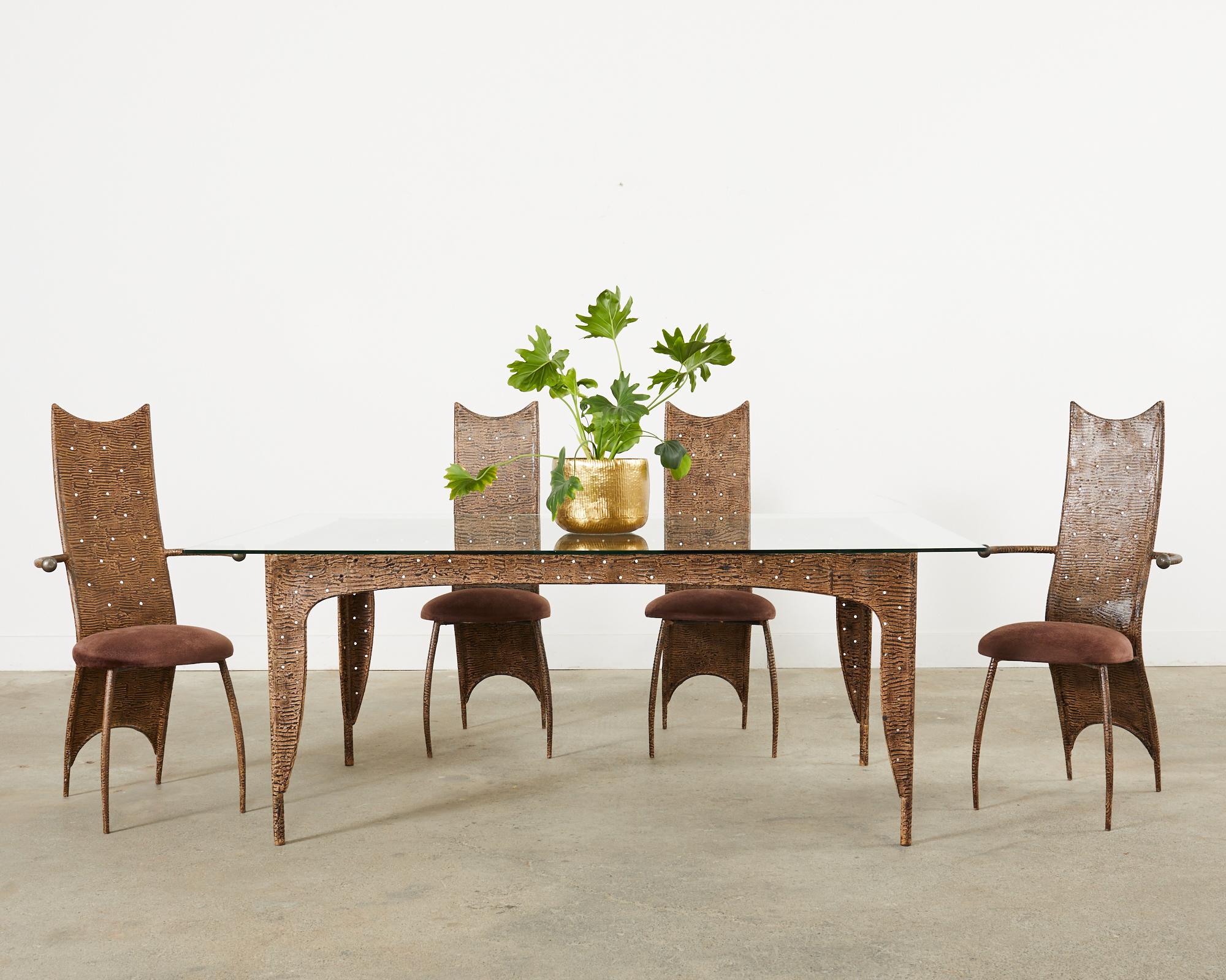 Amazing post-modern steel dining table featuring an applied textured finish that resembles patinated rebar. The table has a smooth texture with a pierced metal apron around all four sides having small holes perforated in the finish. The design has a