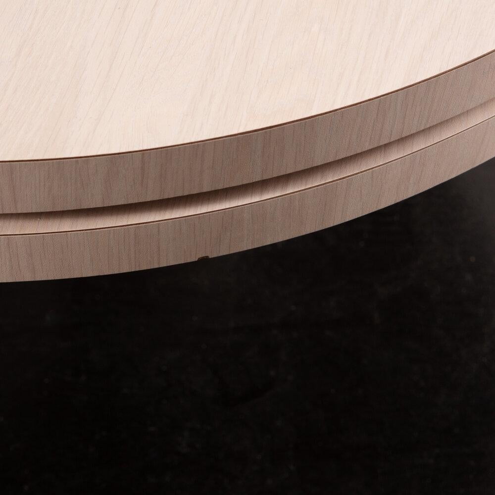 A Postmodern tiered coffee table featuring a rounded top that swivels 360
