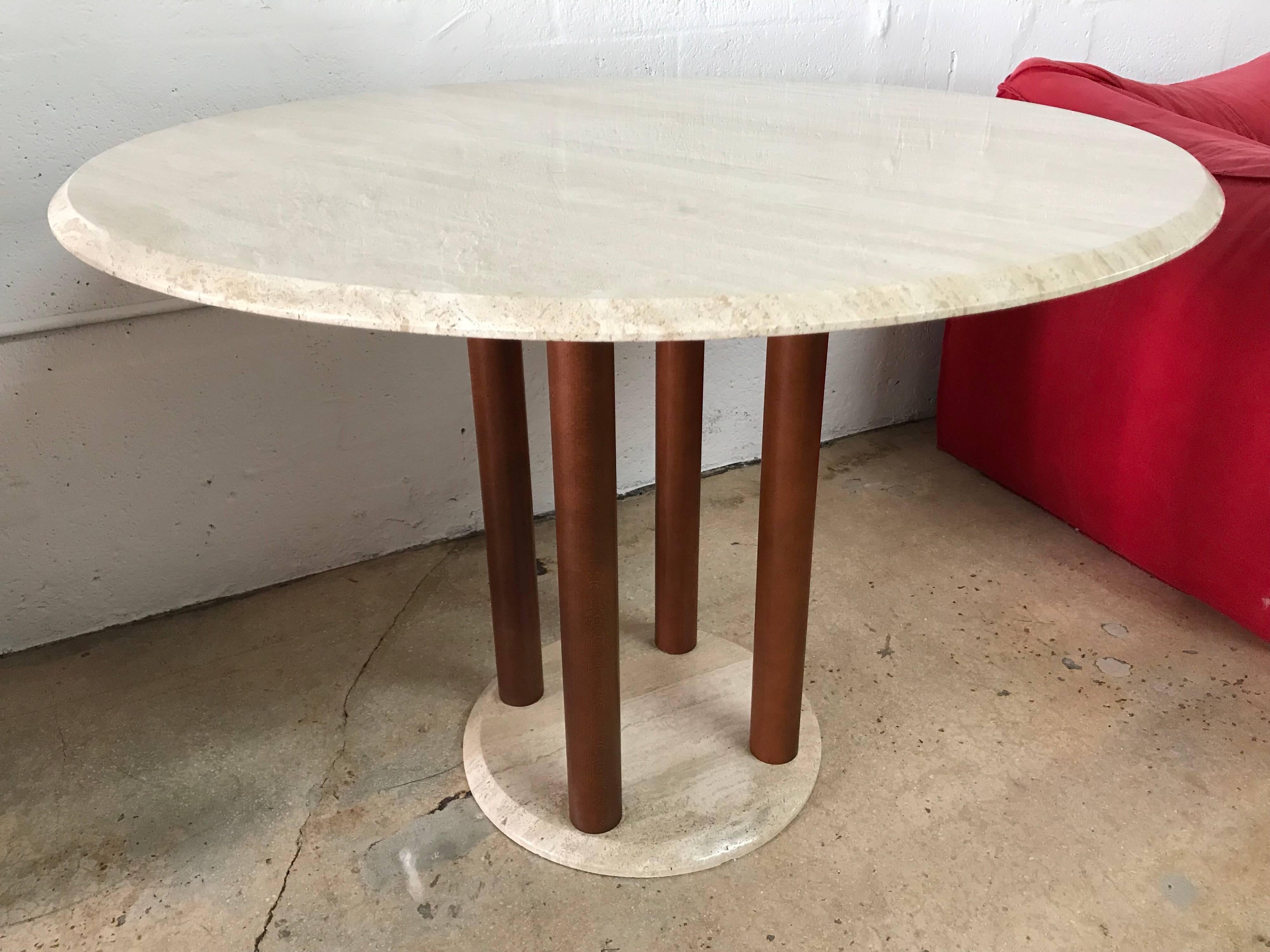 Round postmodern dining table with a top and base rendered in travertine supported by 4 wood cylinder columns designed in the style of Ettore Sottsass for Memphis Group, Italy, 1980s