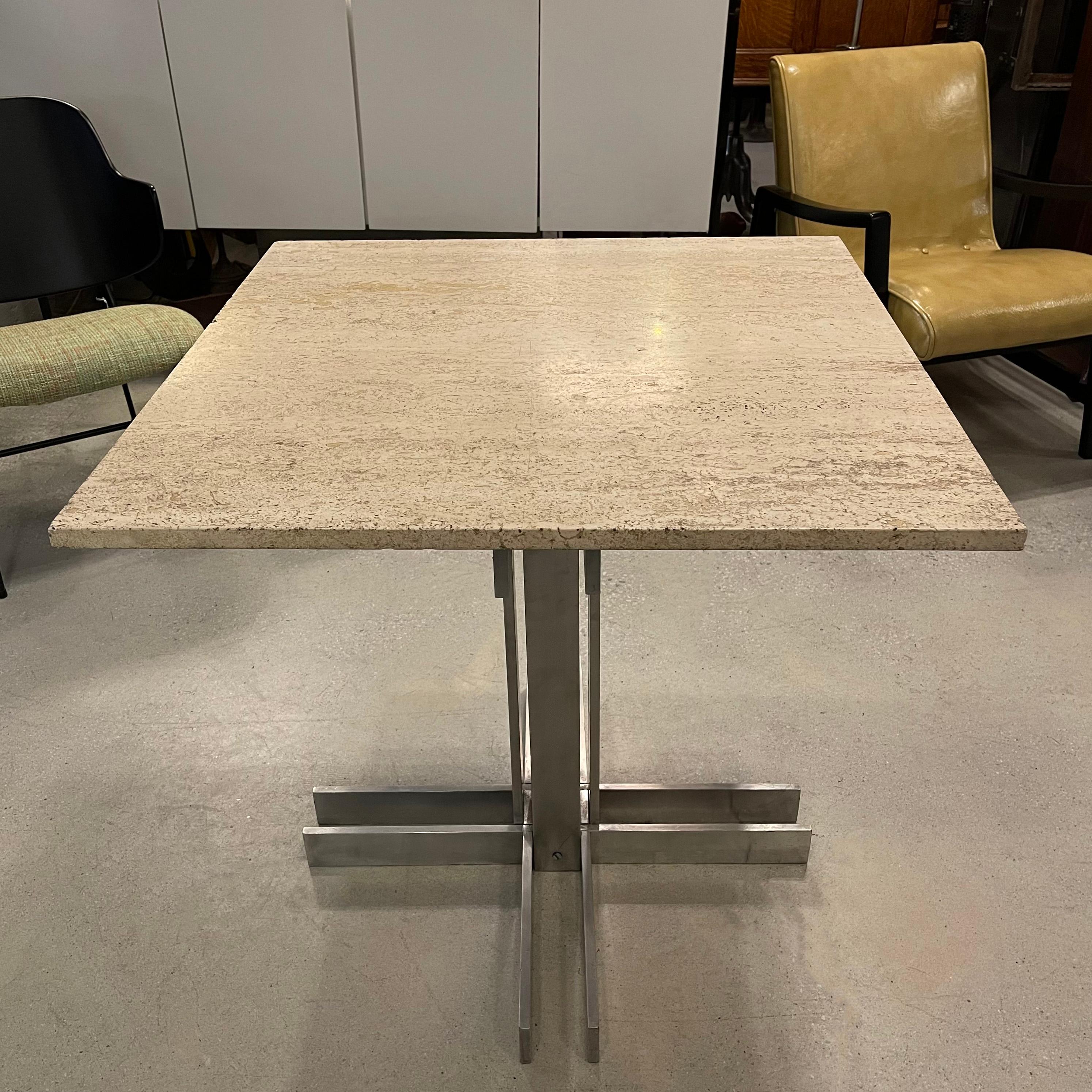 Post modern, Memphis influenced, small dining or bistro café table features a 30 inch square travertine top paired with a post-modern, architectural, machined-aluminum, pedestal base.