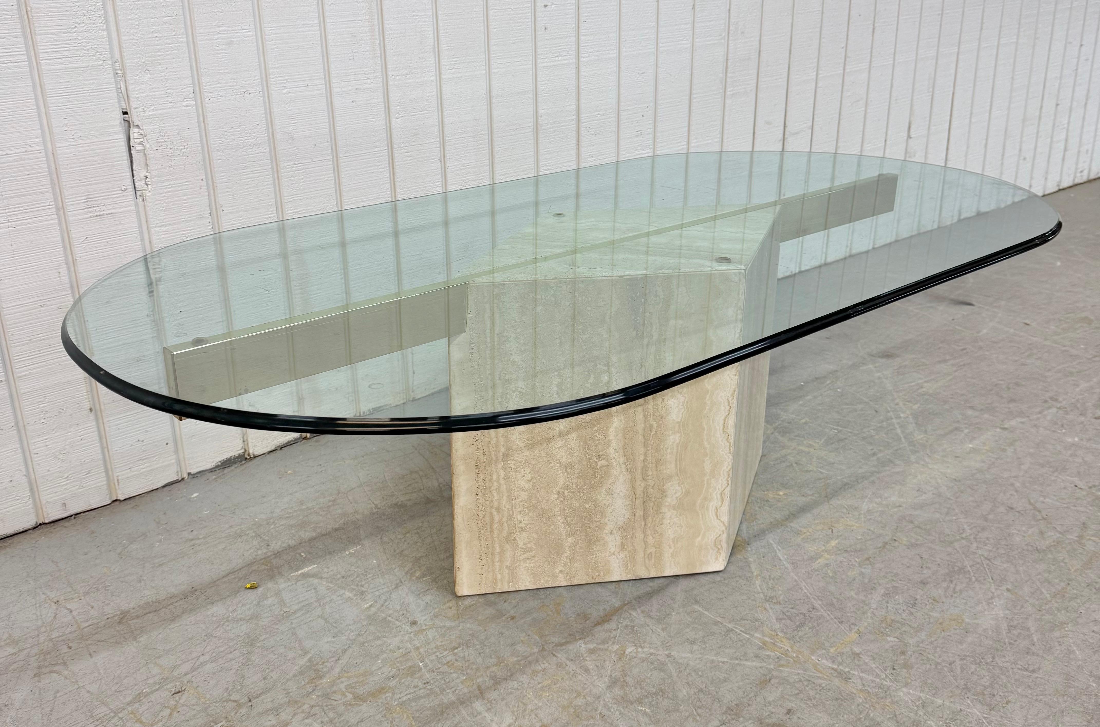 This listing is for a Post Modern Travertine Glass Top Coffee Table. Featuring a post modern design, diamond shaped travertine base, flat bar brass supports, and an oval piece of glass. This is an exceptional combination of quality and modern design!