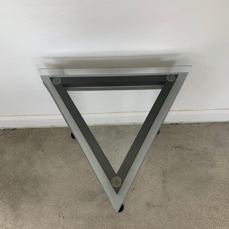 Unique triangular glass and steel drinks or occasional tables rendered in glass and steel with adjustable feet, postmodern design.