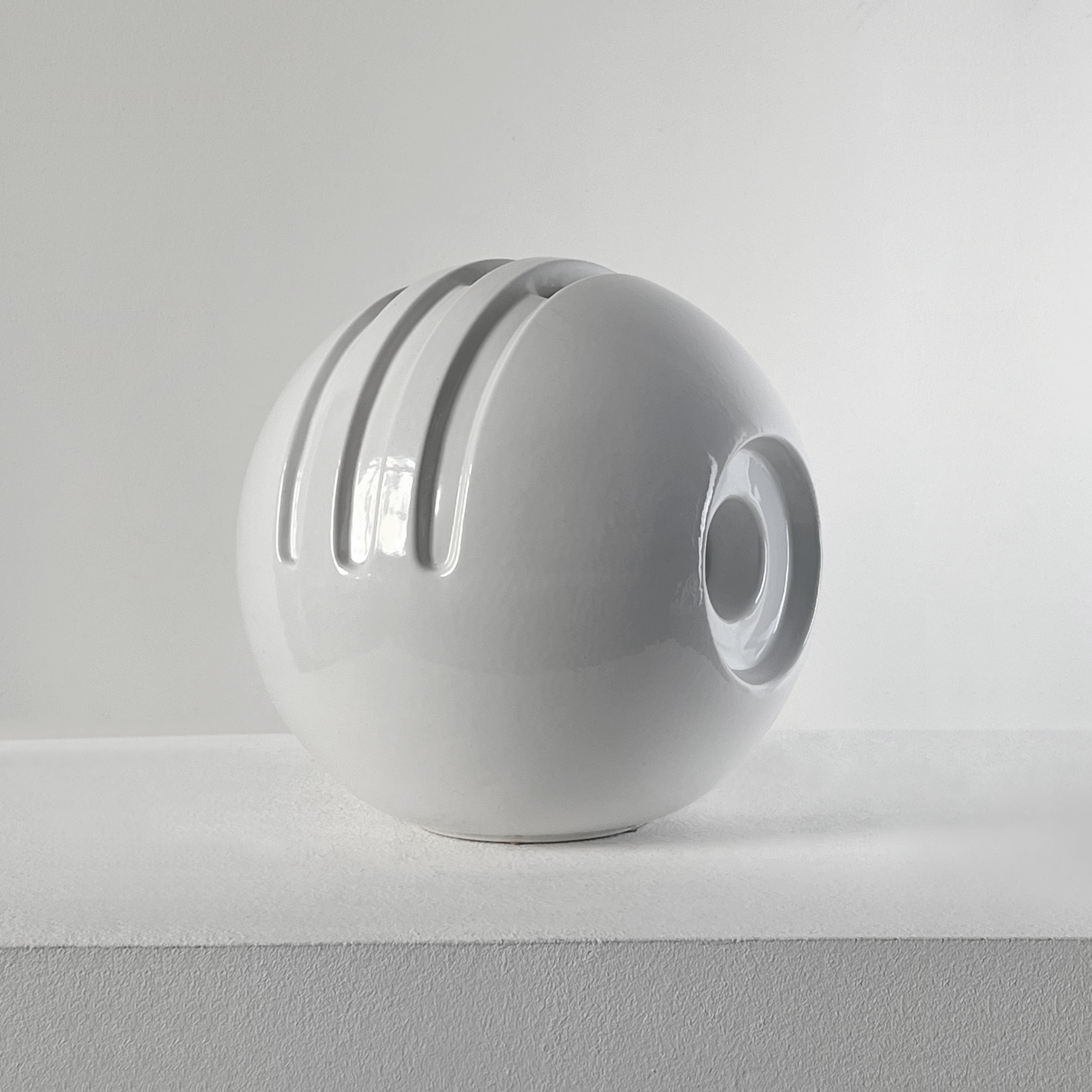 Postmodern ceramic vase designed by Enzo Bioli in the second half of the twentieth century for Il Picchio. In white polished ceramic with geometric shape and cuts of the postmodern style. 
It is not just a vase but a sculptural masterpiece.
Under