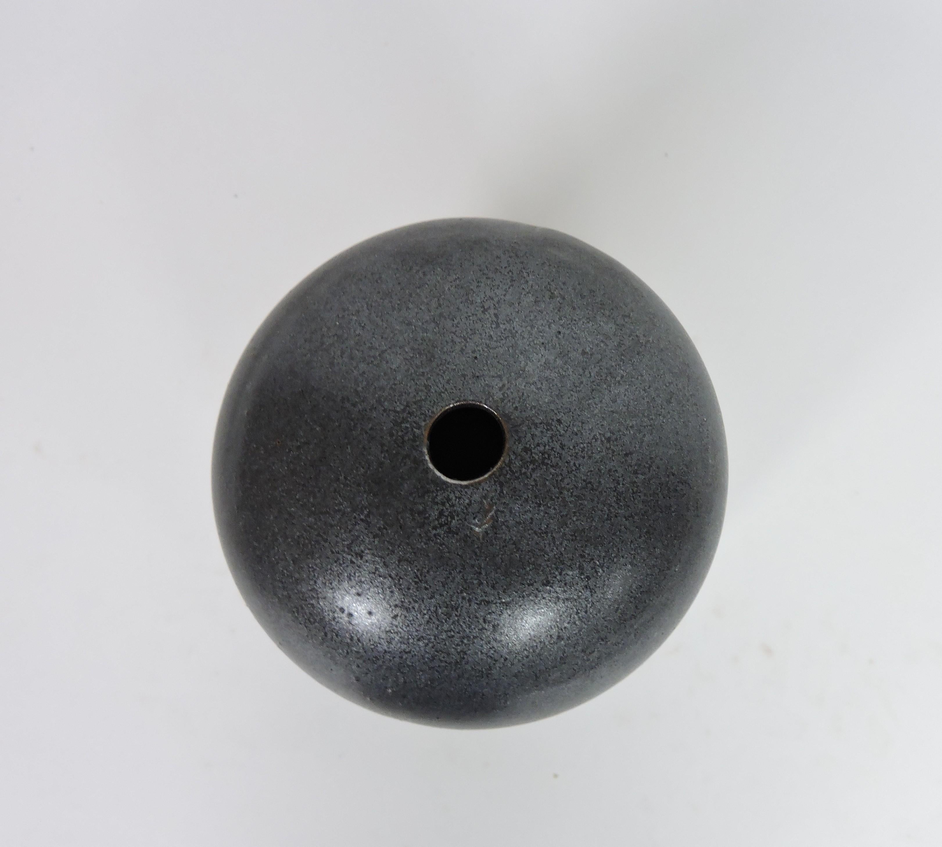 Beautiful post-modern minimalist style cylindrical vase designed by Mexican designer, Victor Carranza, and manufactured in Japan by Mikasa. This vase has an Asian influenced form and a striking gunmetal glaze. Signed Victor Carranza on the bottom