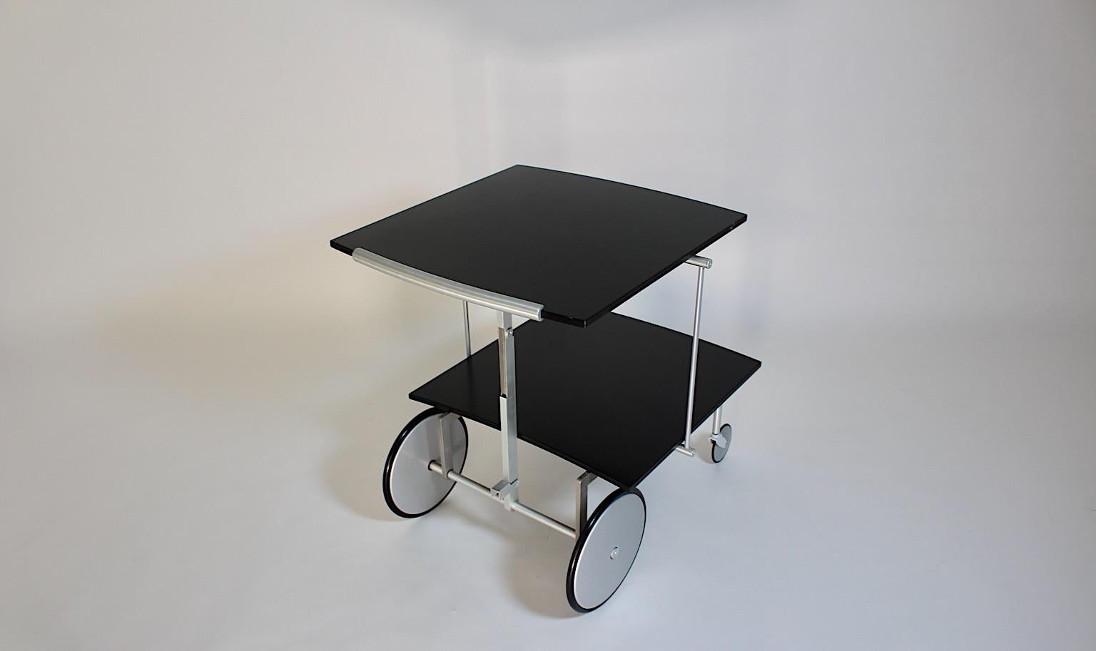 Carro de bar o mesa de sofá híbrido postmoderno vintage de aluminio y fórmica en color negro y plata por Raul Barbieri para Ycami años 90, Italia.
Precioso carrito de bar con ruedas y mesa de sofá en una sola pieza, este carrito de bar ajustable de