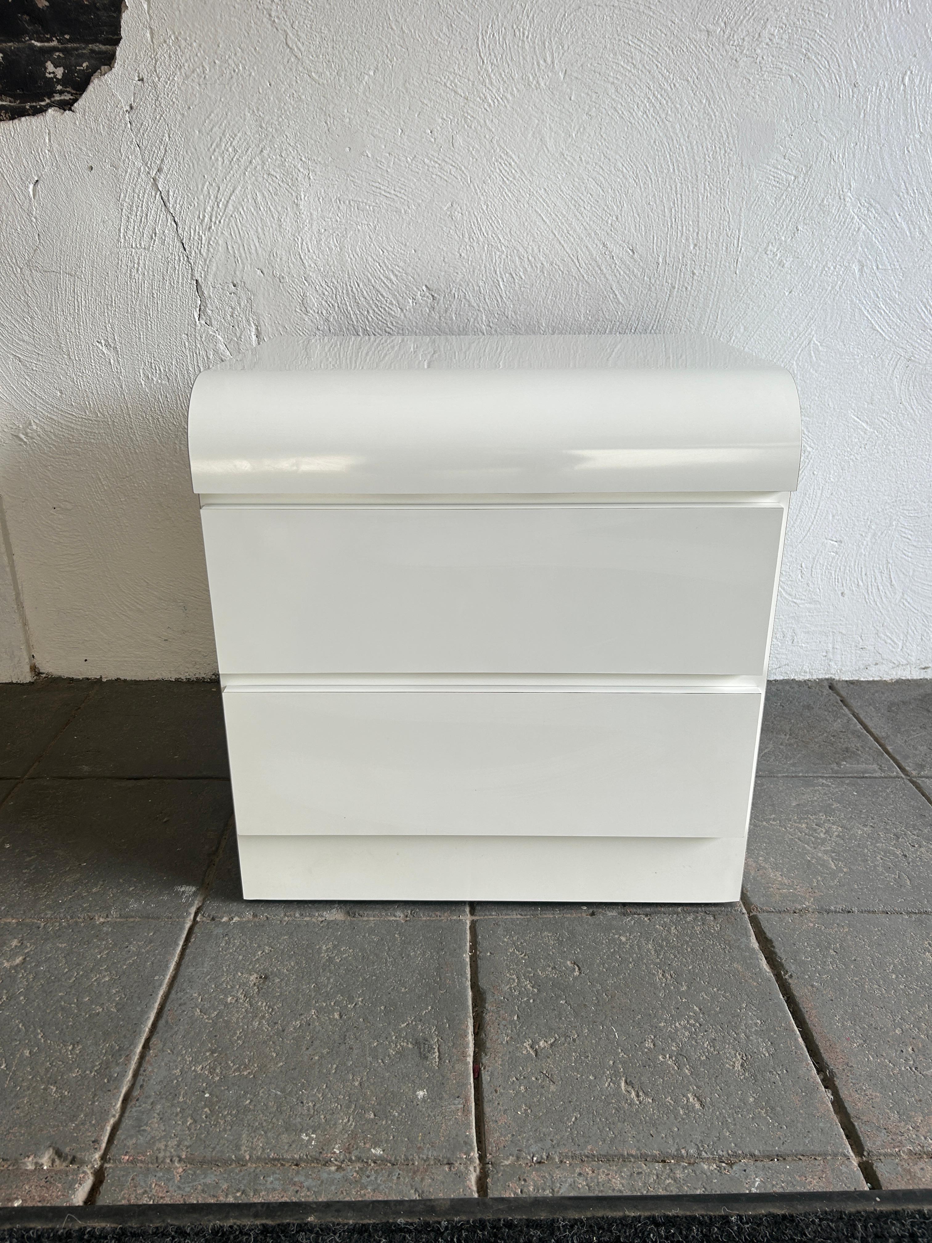 beautiful post modern white gloss laminate waterfall front 2 drawer nightstand, circa 1980. Very clean inside and out almost like new. Look at photos. Both drawers have metal glides with stops. Great for home, office, art studio/gallery or retail