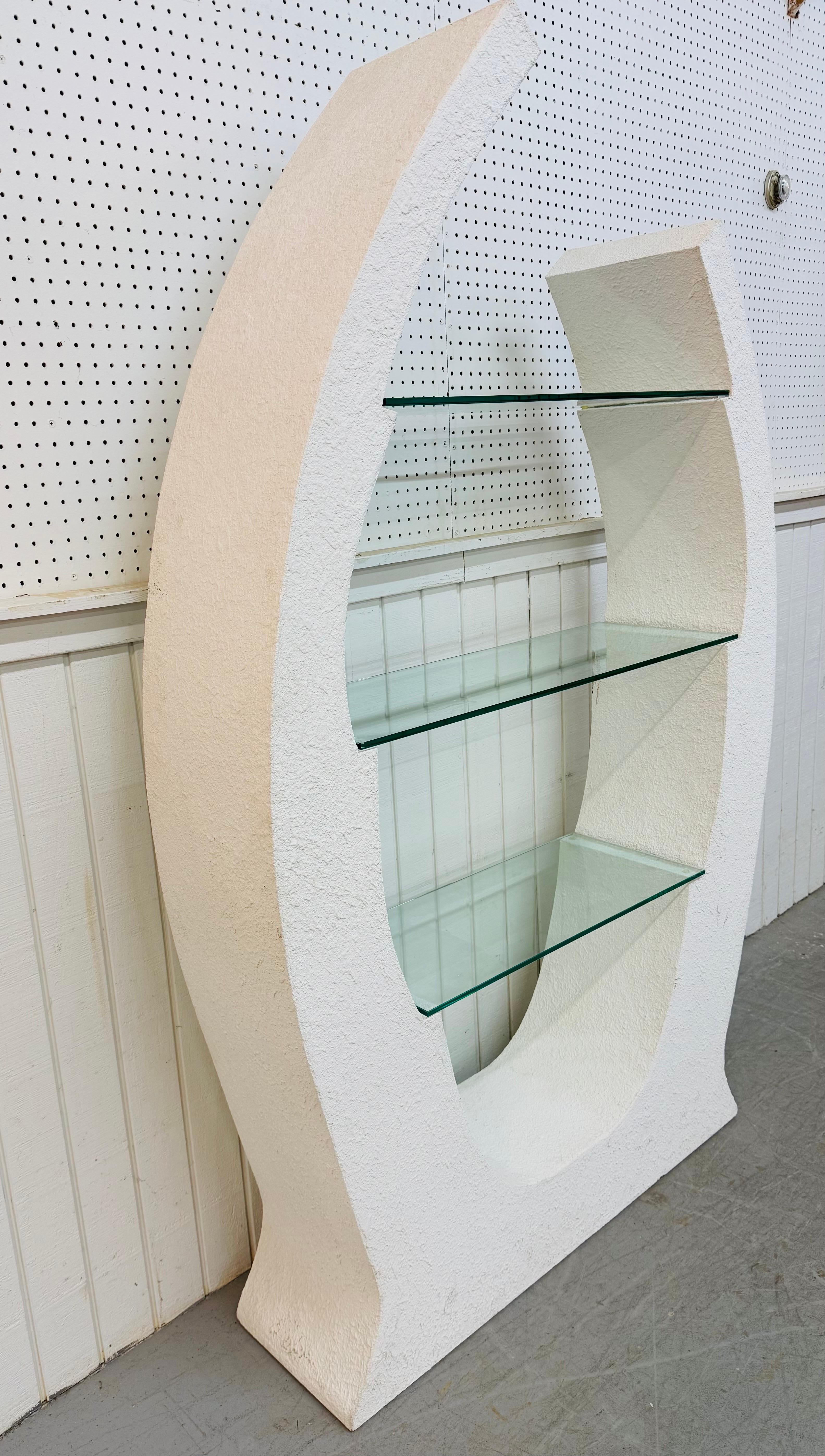 Questo annuncio si riferisce a un'Etagere postmoderna scolpita in stucco bianco. Caratterizzato da un design curvo in stucco bianco post-moderno e da tre ripiani in vetro per l'esposizione. Si tratta di una combinazione eccezionale di qualità e