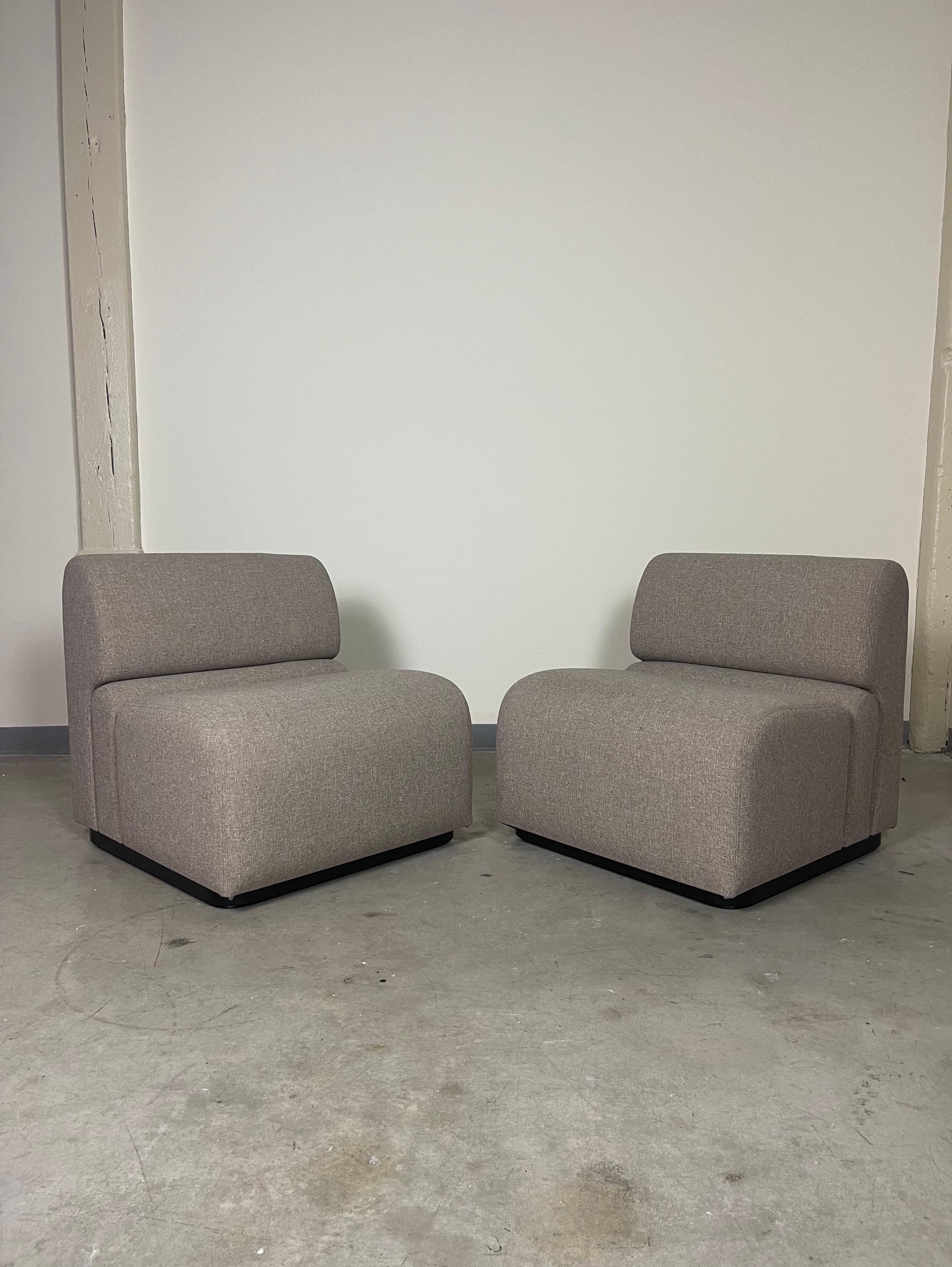 Unique pair of post modern slipper chairs in original wool. Chairs are manufactured by Jack Cartwright and retain the original sales tags and labels. Original upholstery is in excellent condition with no flaws. Black metal bases have some minor