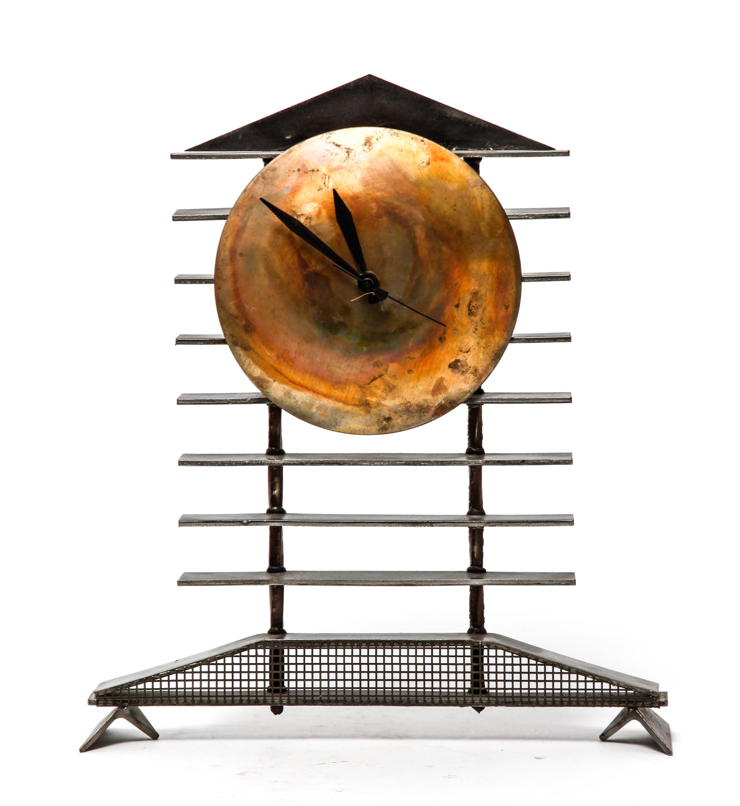 Post-modernist mantel clock made of steel and brass. The piece has a quartz battery movement in the back and is in great vintage condition, with some minor age-related wear to the metal surfaces.