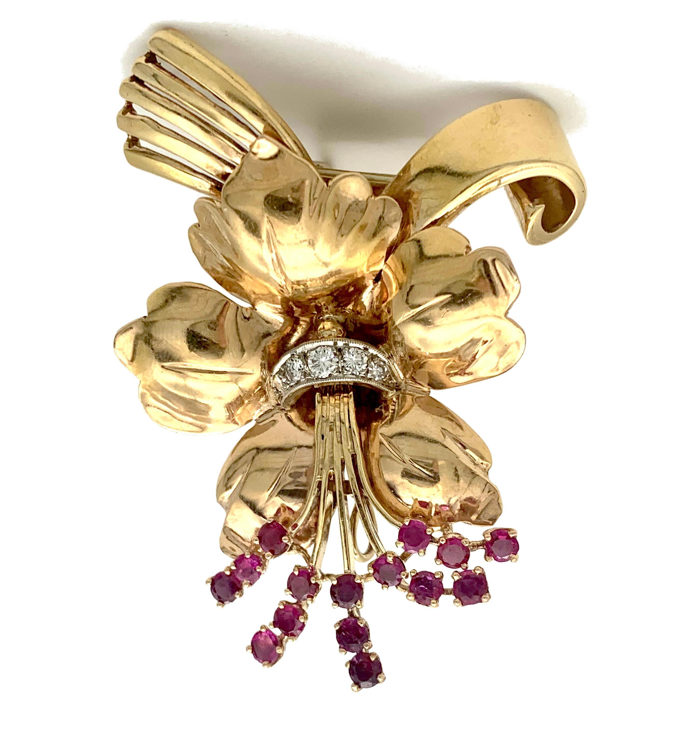 This striking demi parure consists of a pendant in the shape of an orchid and matching good size orchid clip-on- earrings. The set was made in the late 1940's out of 14 carat rose gold and platinum. Out of a platinum element decorated with diamonds
