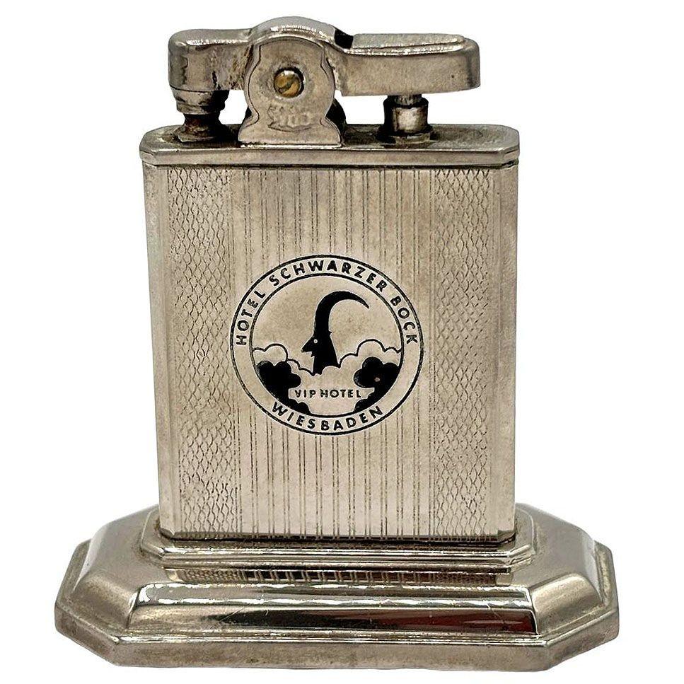 Briquet de table chromé datant d'après la Seconde Guerre mondiale, avec une base à gradins remarquable aux lignes géométriques et aux détails élégants, portant l'inscription 